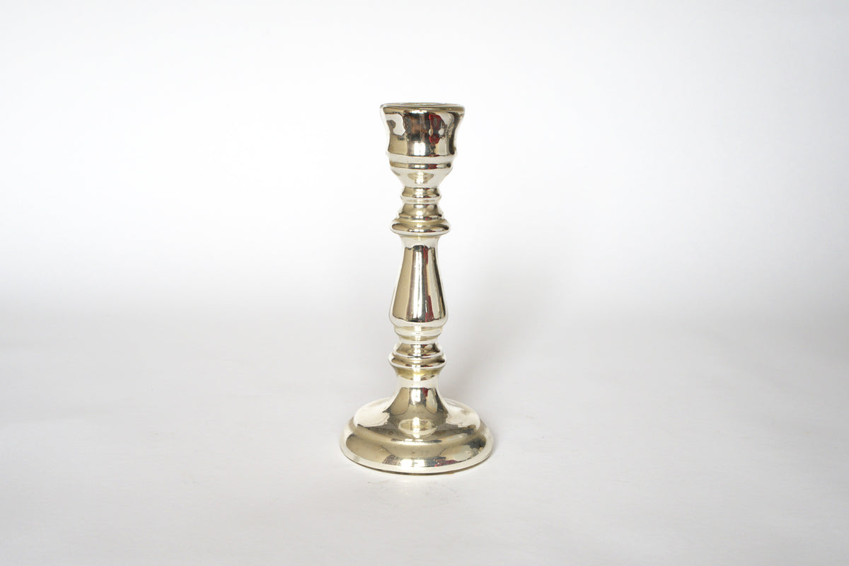 A pair of vintage mercury glass candleholders by Euro Trash, featuring round bases, slender decorative stems, and cups for candles, evoke classic elegance against a plain white background.