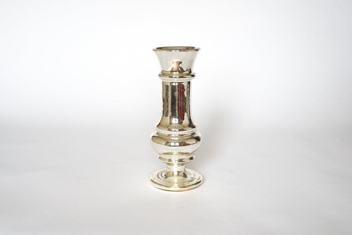 A pair of vintage mercury glass candleholders by Euro Trash, featuring a shiny silvered finish with rounded bases and flared tops, stands upright against a plain white background.
