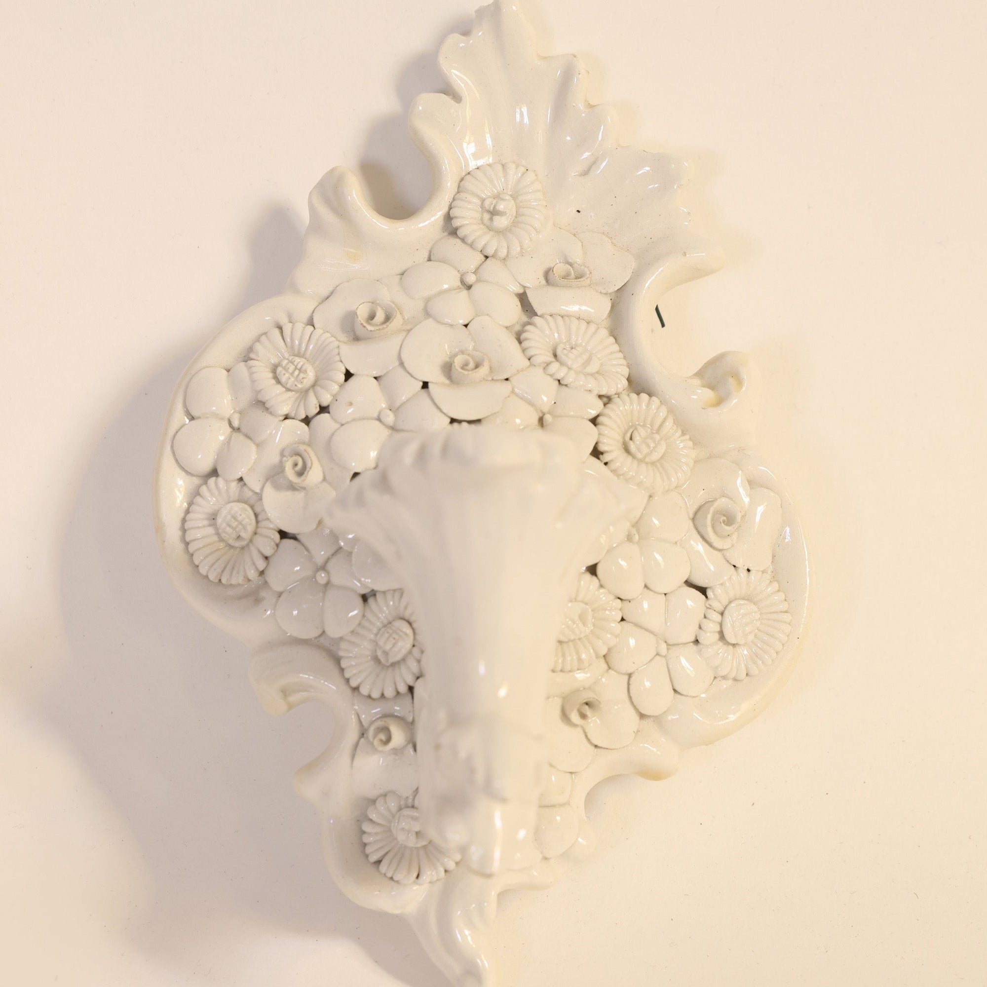 Pair of Porcelain Floral Wall Pocket Vases by Euro Trash, featuring detailed flower designs and decorative leafy edges, reminiscent of vintage ceramic wall decor, displayed against a plain light background.