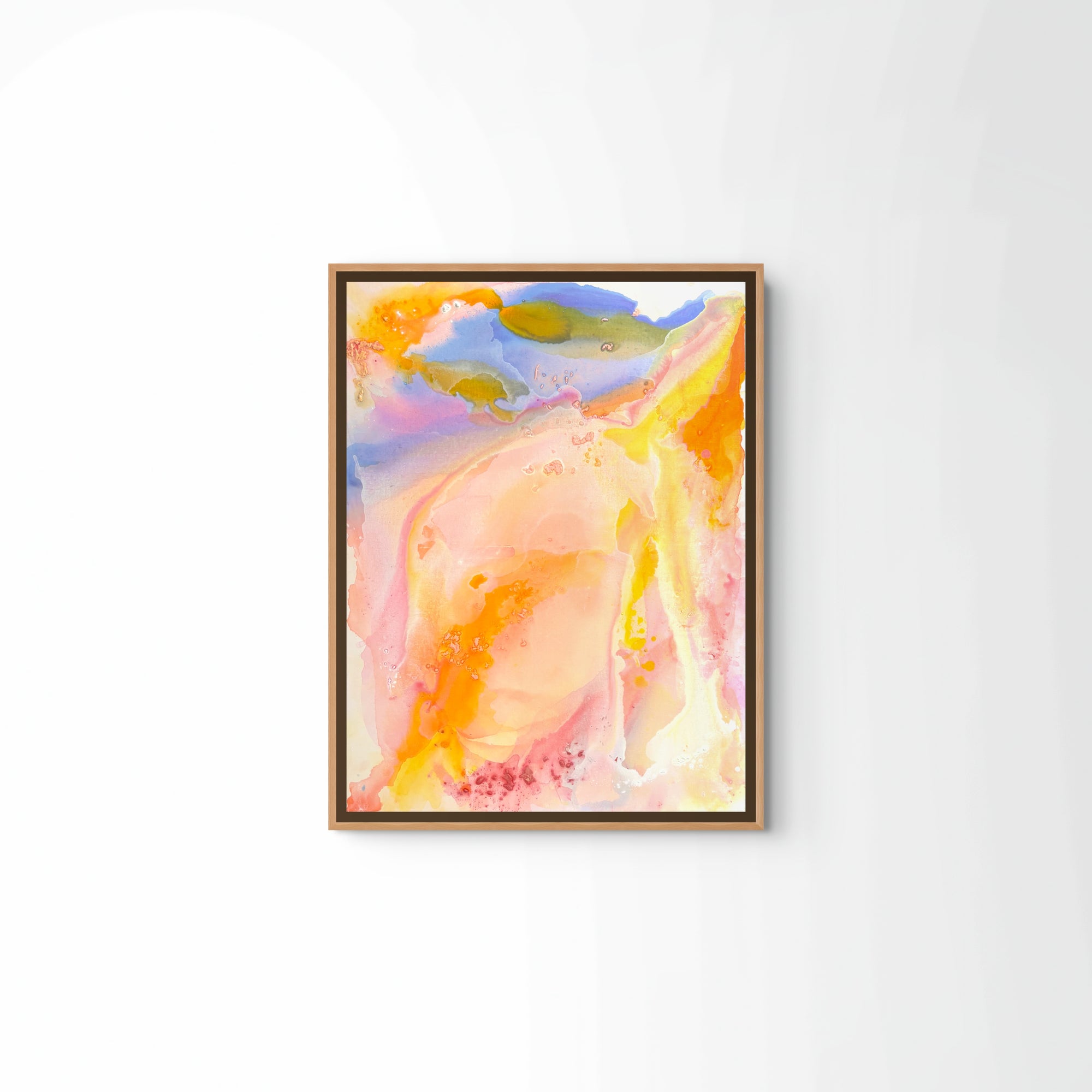Sunset after a storm," a framed abstract watercolor by Euro Trash, features swirls of pink, yellow, orange, and blue reminiscent of Andalucia sunsets and is shown hanging on a white wall.