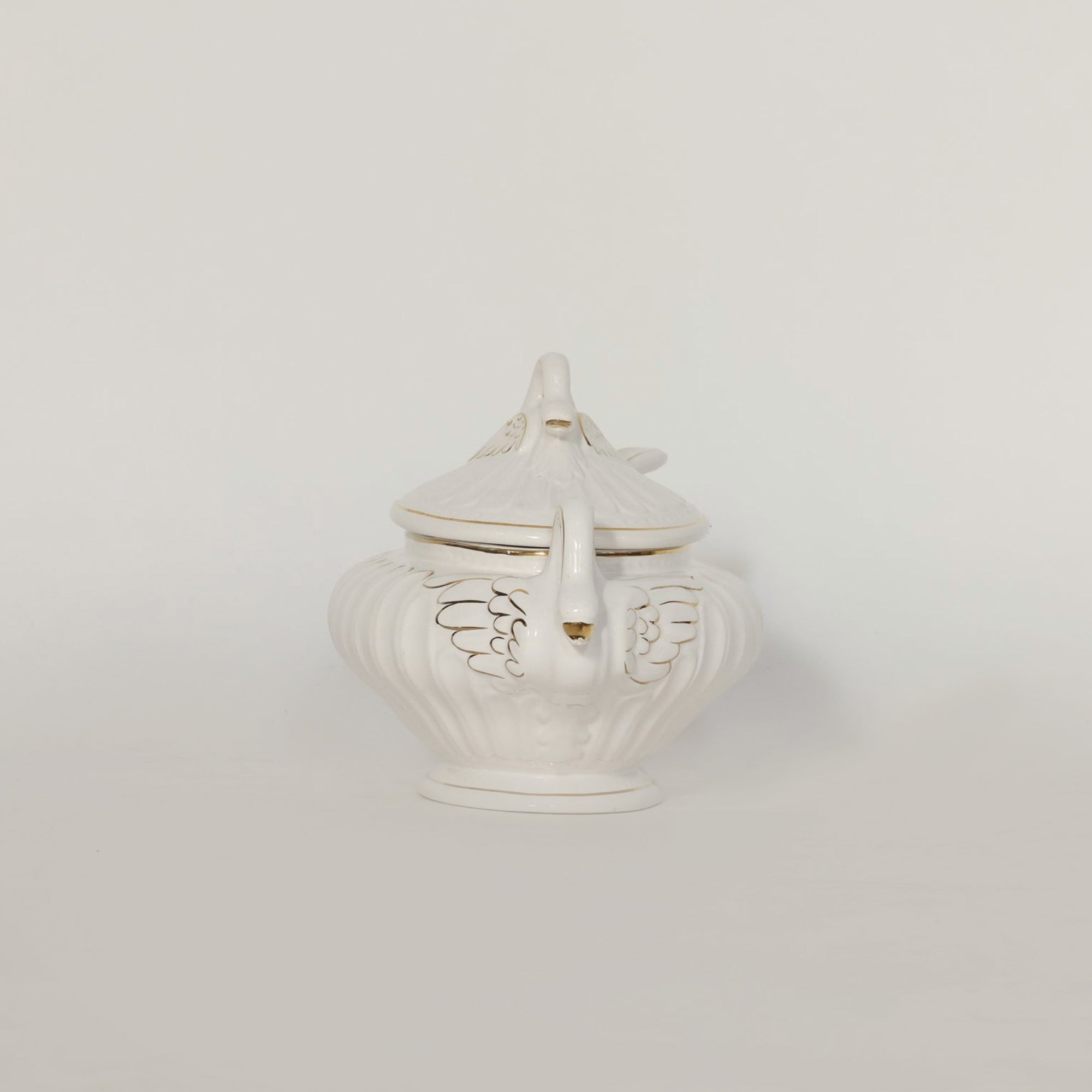 White ceramic tureen with decorative lid on a light gray background