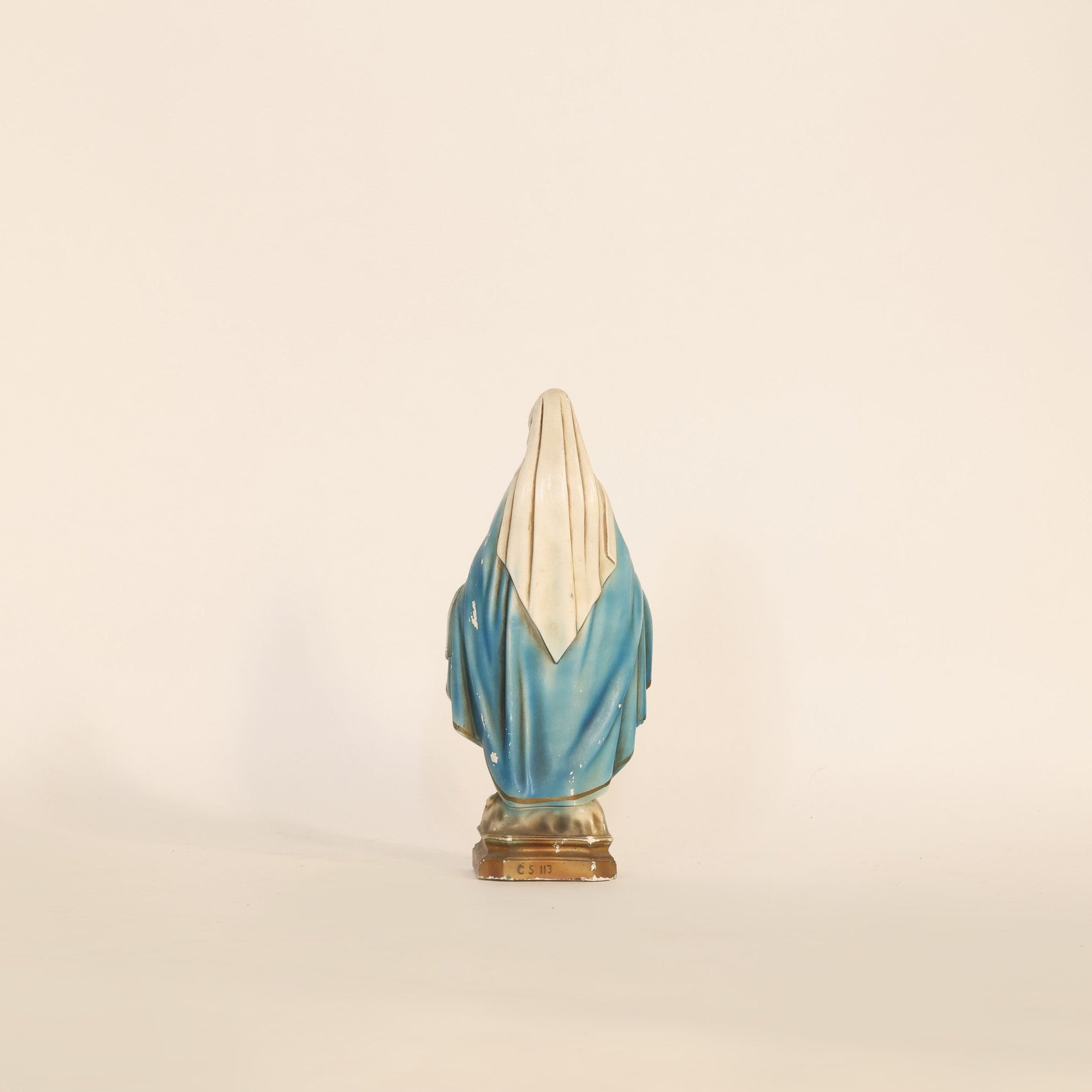 Statue of a religious figure on a beige background