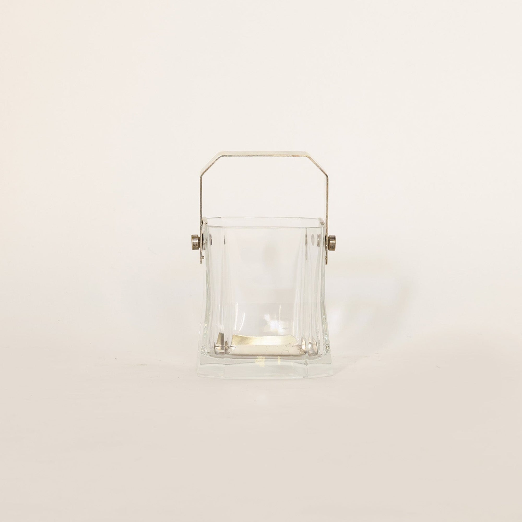 Vintage vessel composed of crystal and brass on beige background 