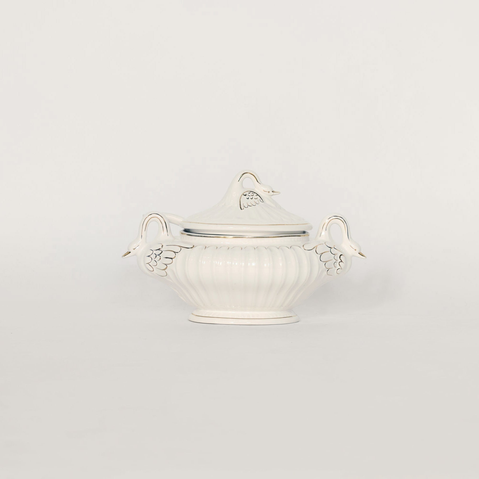 White & gold trimmed decorative bowl with handles on a light gray background