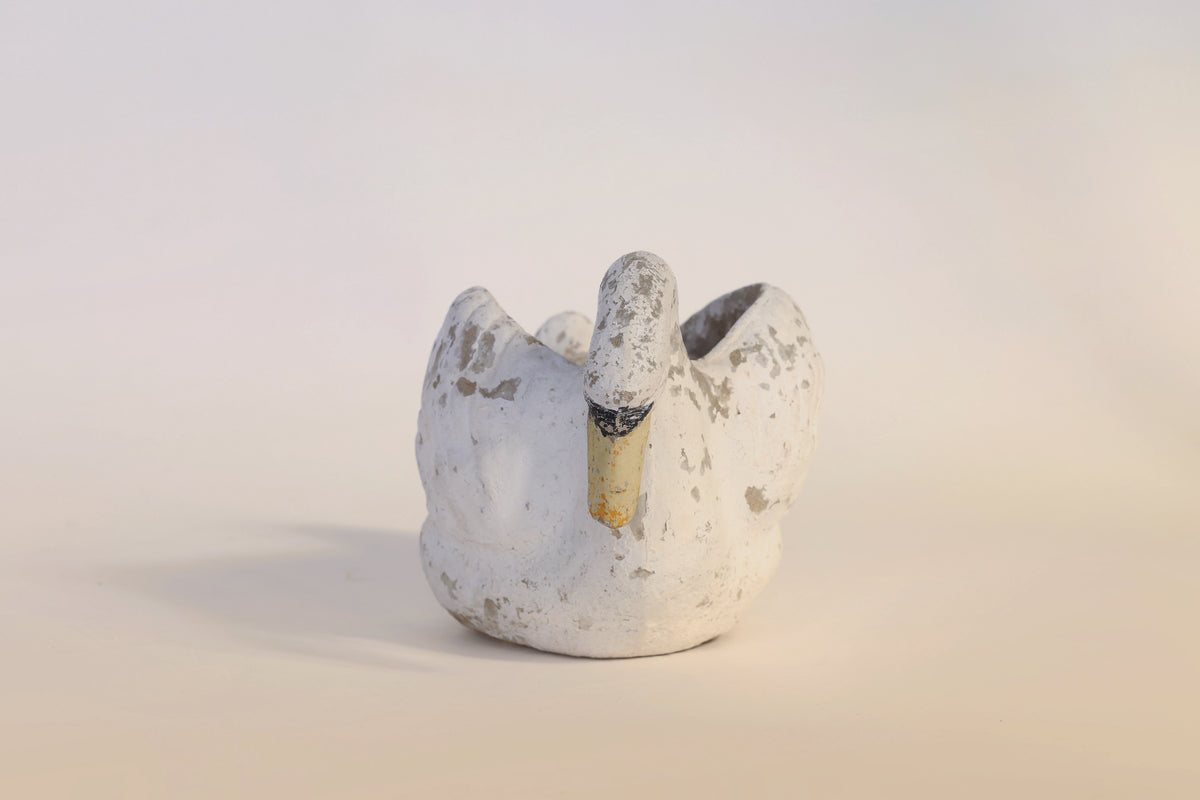 The Vintage Distressed Swan Planter by Euro Trash Annie features a small, weathered white ceramic swan with a charmingly chipped beak and a distressed finish, set against a simple light background—an ideal sculptural accent for any space.