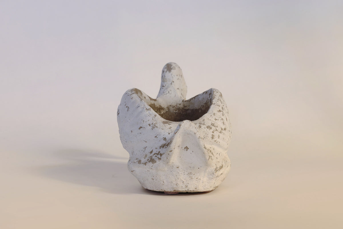 Introducing the Vintage Distressed Swan Planter by Euro Trash Annie—a small, abstract white ceramic sculpture with a rough, distressed finish and organic shape, featuring a rounded form with a central raised section reminiscent of a swan.