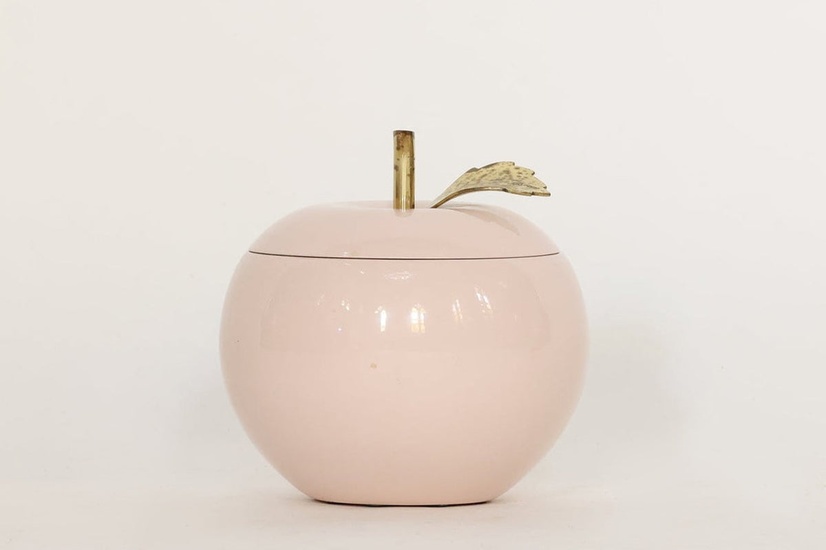 A charming Vintage Pink Apple Ice Bucket by Euro Trash, featuring a pink apple-shaped design with a gold stem and small gold leaf on top, is set against a plain white background—perfect for anyone looking to add unique decorative barware or chic vintage style to their entertaining space.