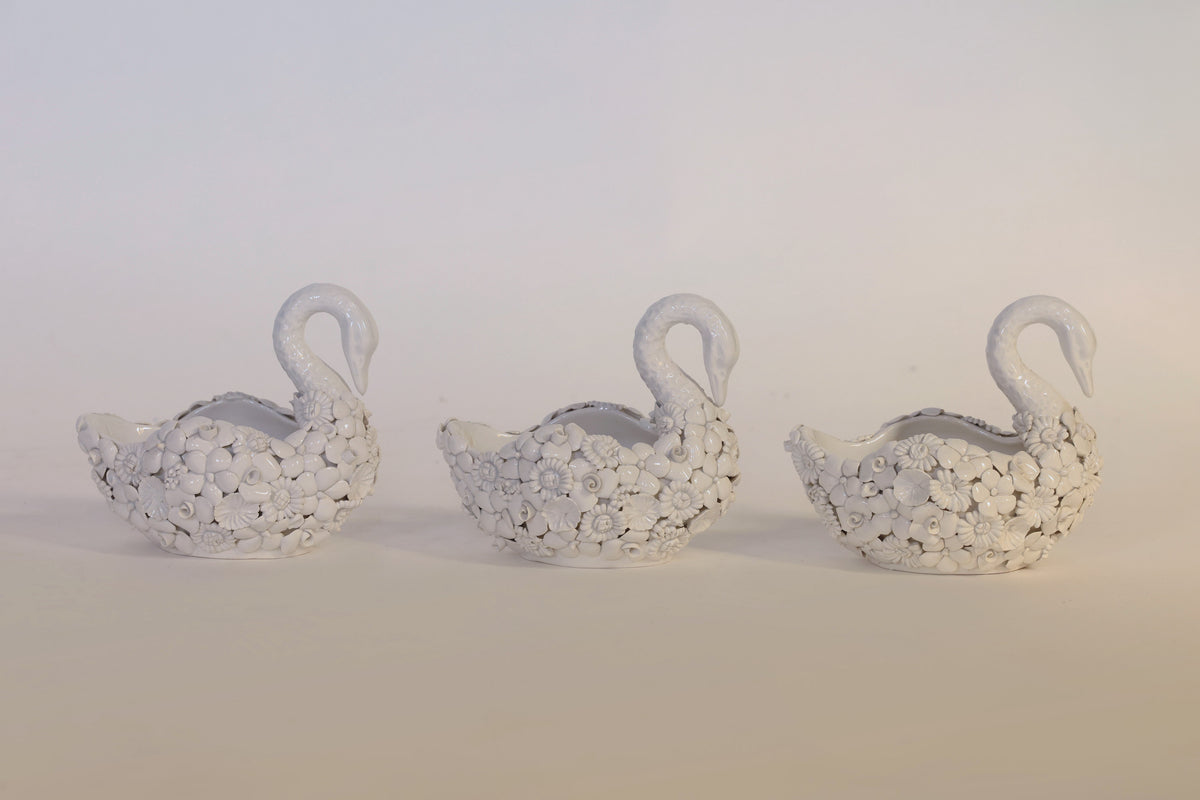 A charming set of three small, white ceramic swan planters from Euro Trash Annie, each adorned with exquisite floral detailing, is displayed side by side against a plain light background—ideal decorative accents for any vintage-inspired space.