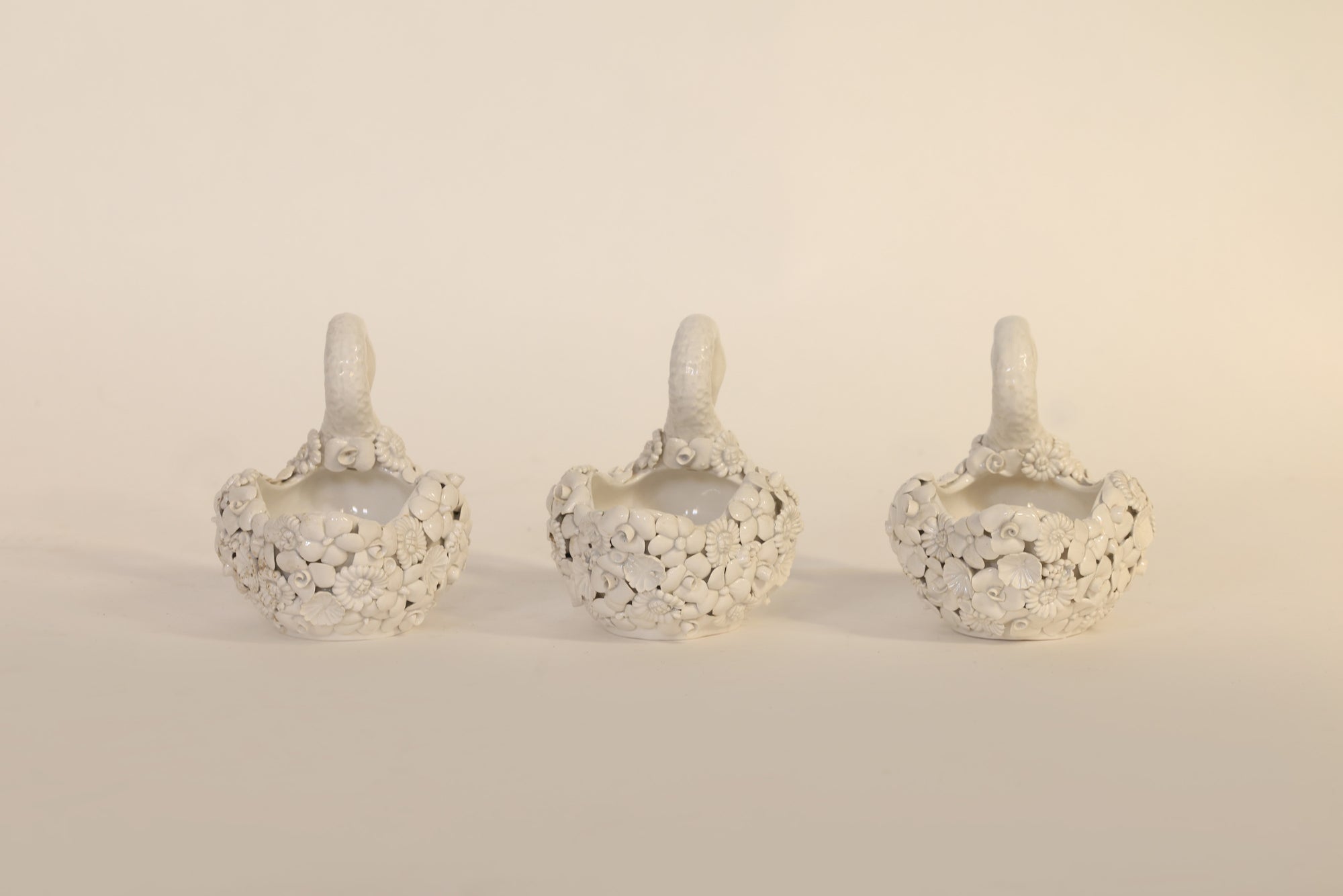 Three decorative items with floral patterns on a beige background