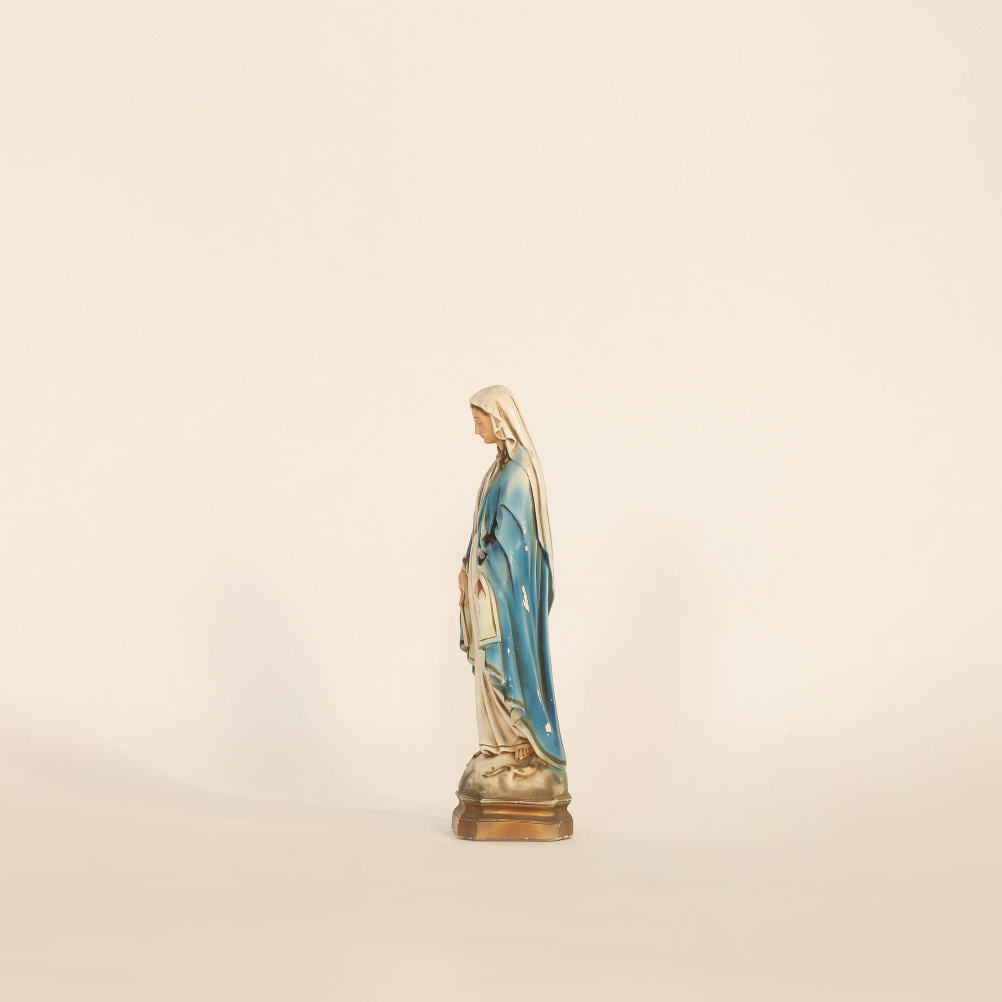 Statue of a religious figure on a beige background