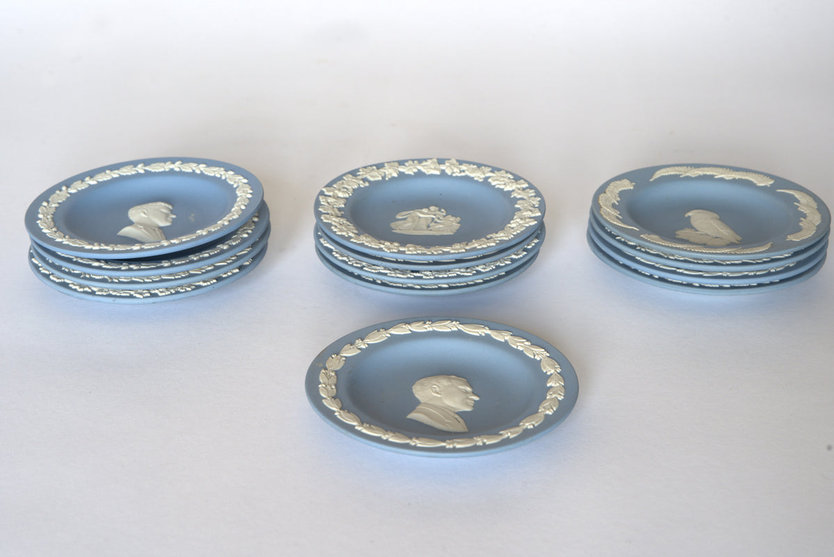 Five stacks of Euro Trash Vintage Blue Jasperware Style Relief Plates are arranged on a white surface. In front, a plate with a man's profile completes this elegant decorative display set.
