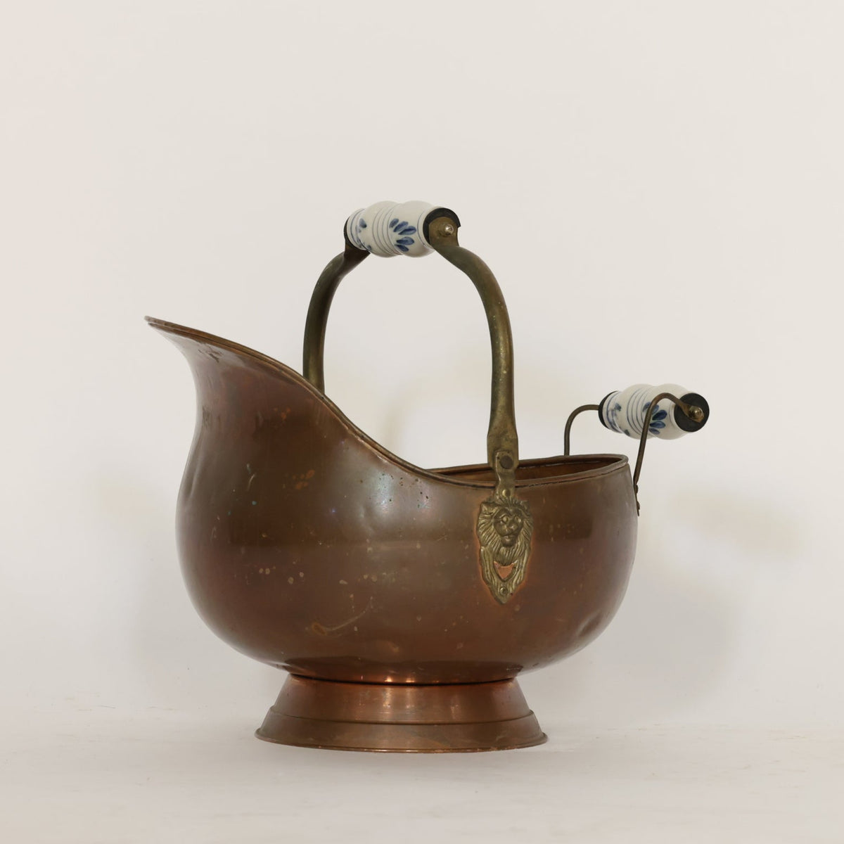 Bronze scuttle with handles and lion emblem on a white background