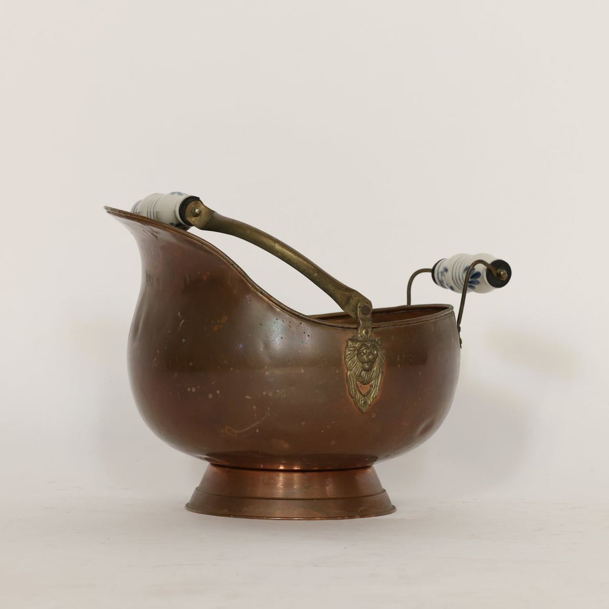 Bronze scuttle with handles and lion emblem on a white background