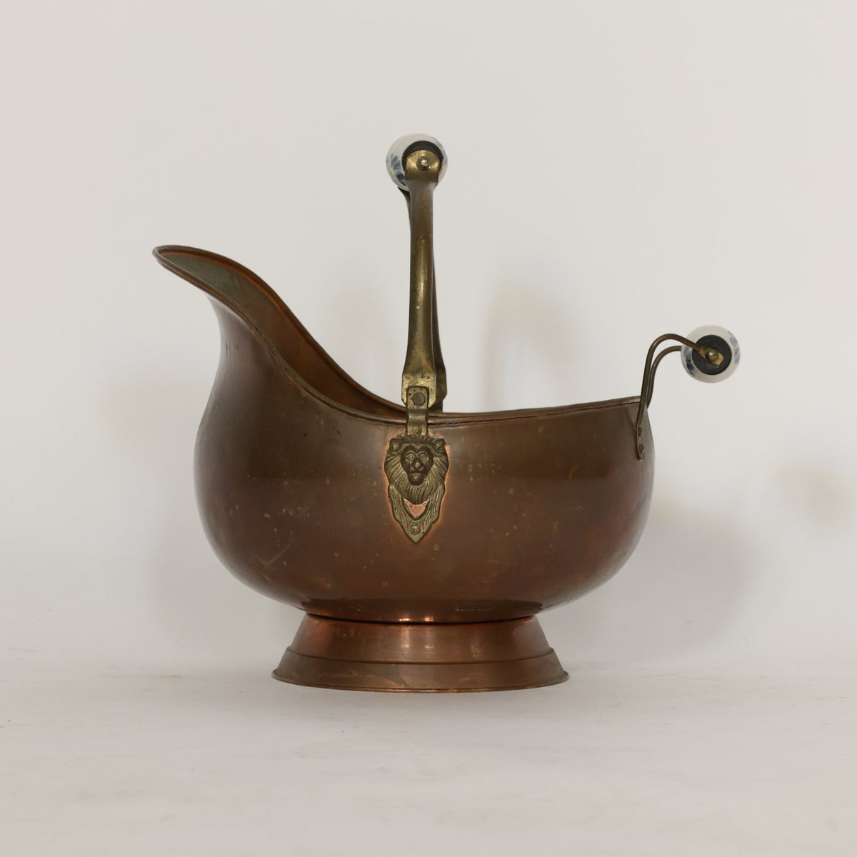 Bronze scuttle with handles and lion emblem on a white background