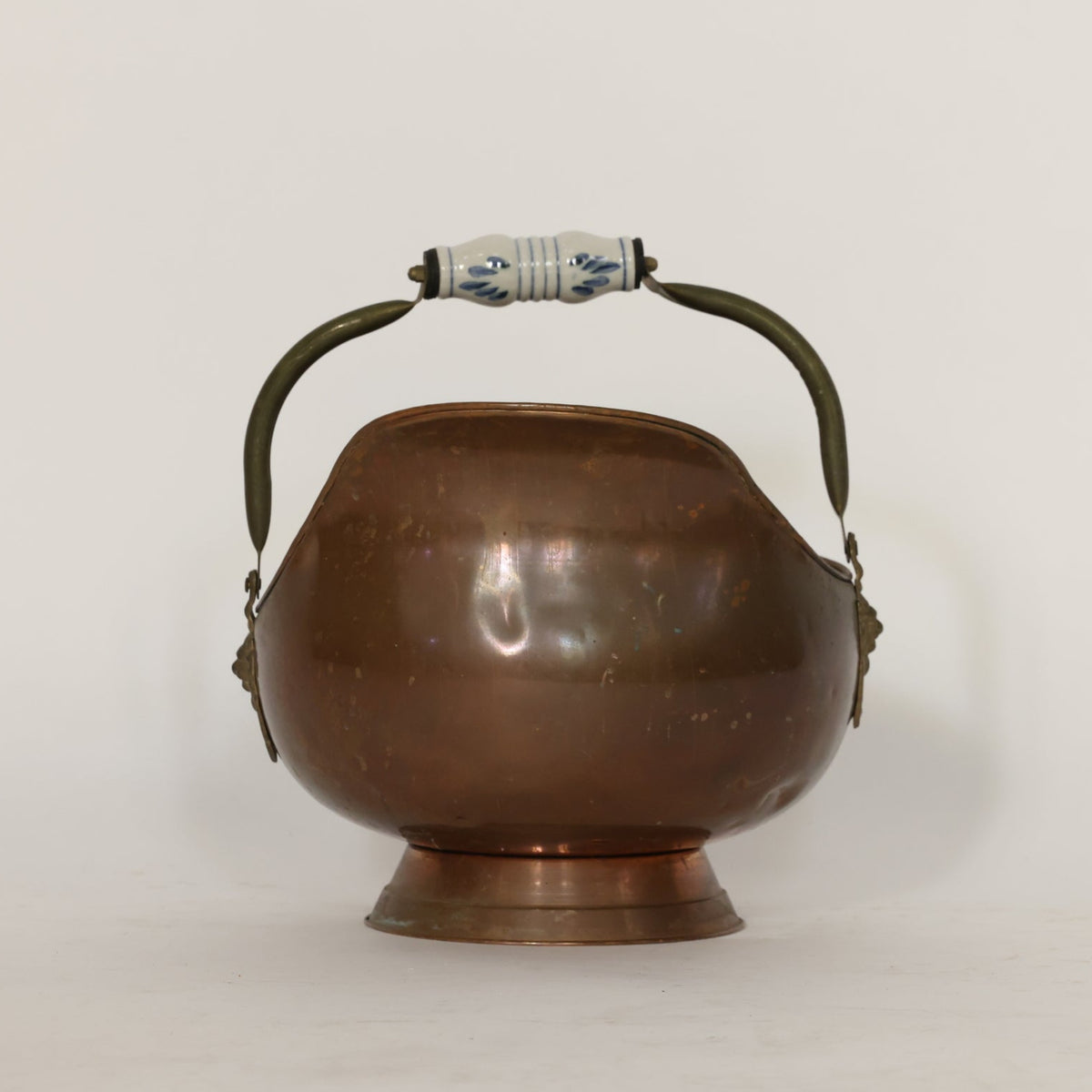 Bronze scuttle with handles and lion emblem on a white background