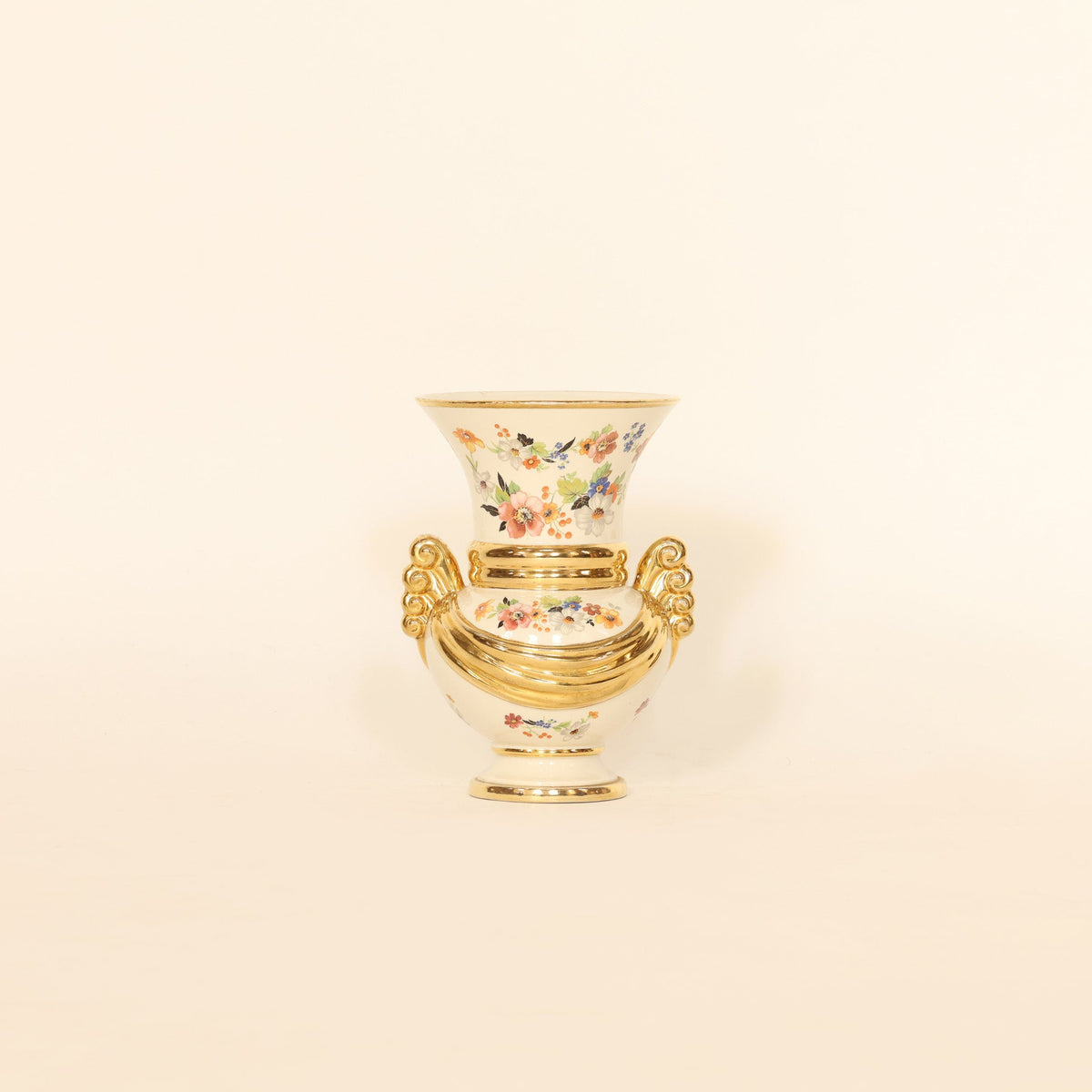 Decorative vase with floral design and gold rim on a beige background
