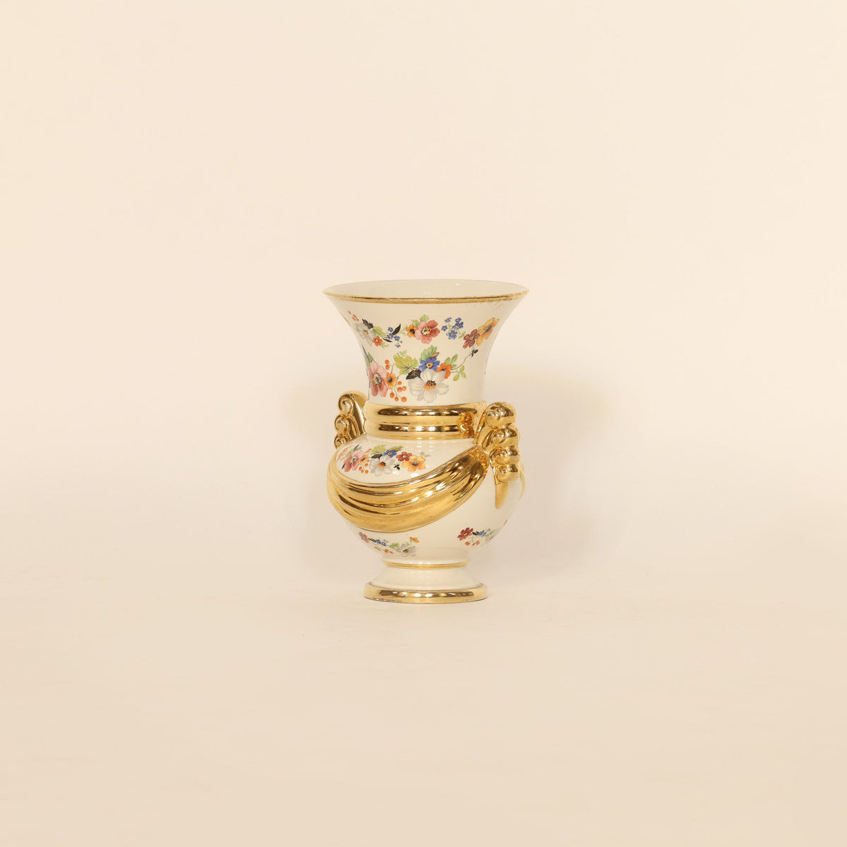 Decorative vase with floral design and gold accents on a beige background