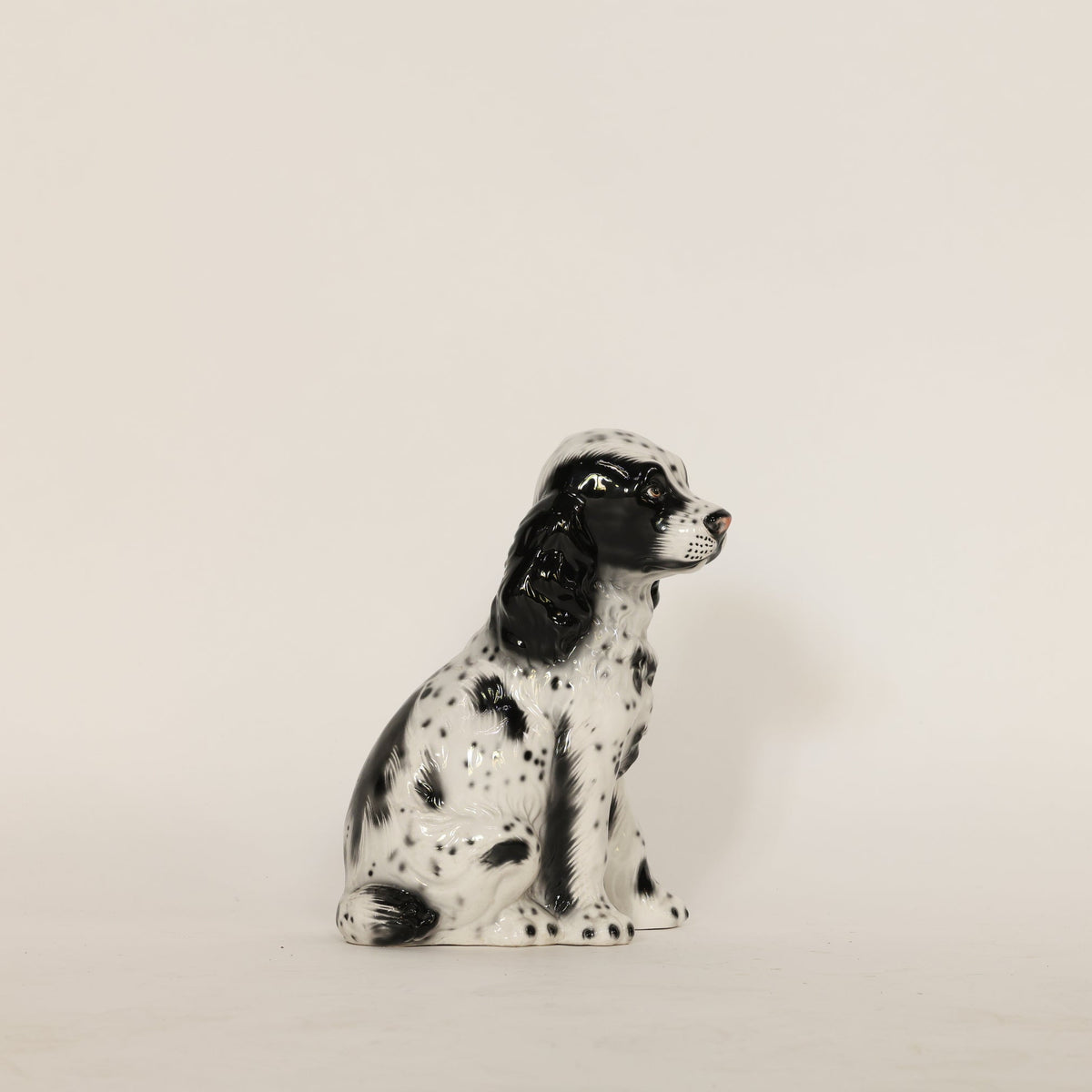 Ceramic dog figurine on a beige background
