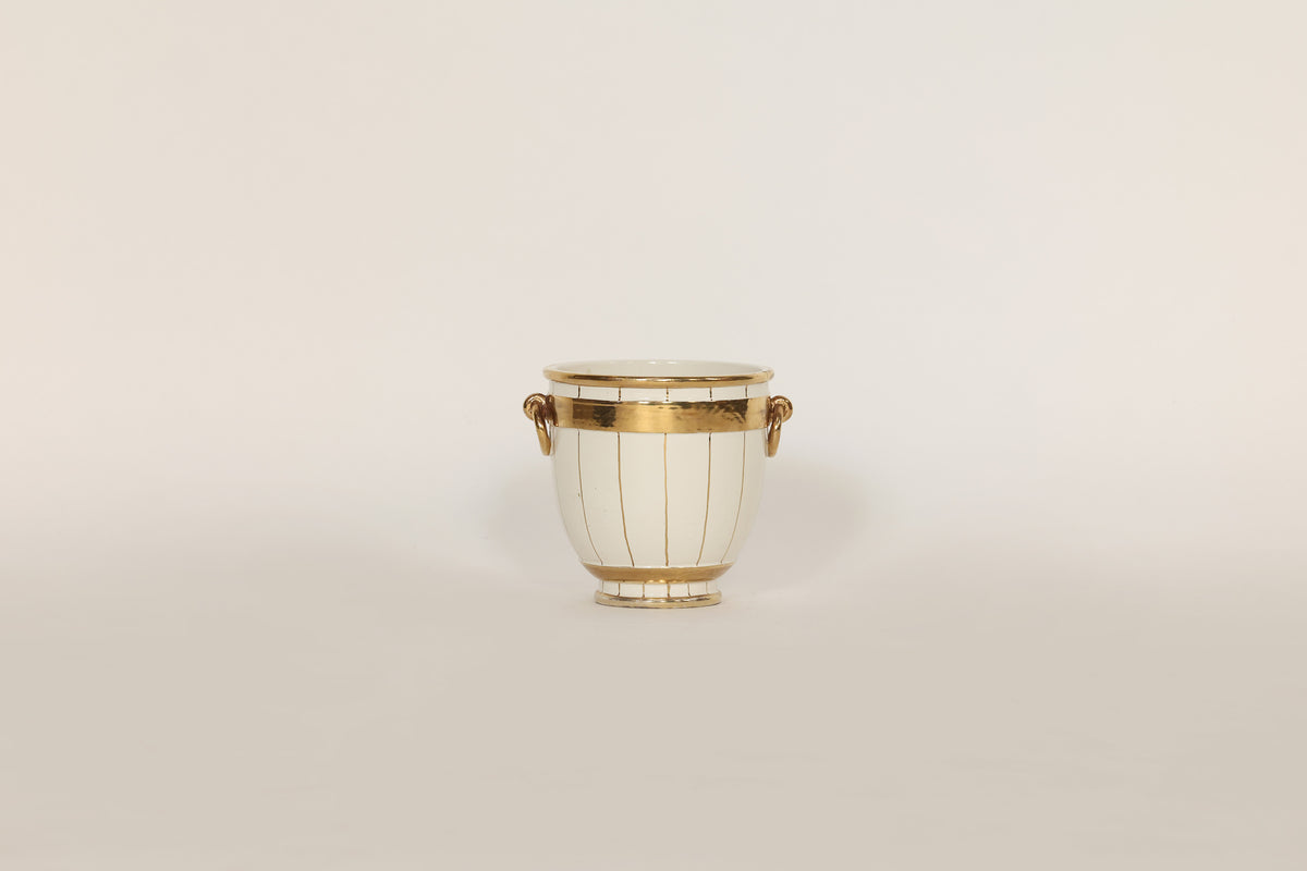Decorative vase with gold accents on a beige background