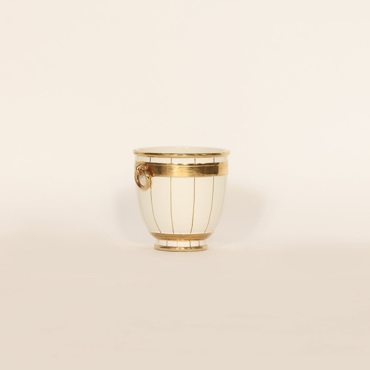 Decorative vase with gold accents on a beige background