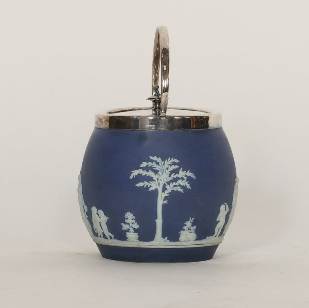 Blue ceramic jar with white decorative patterns on a light gray background