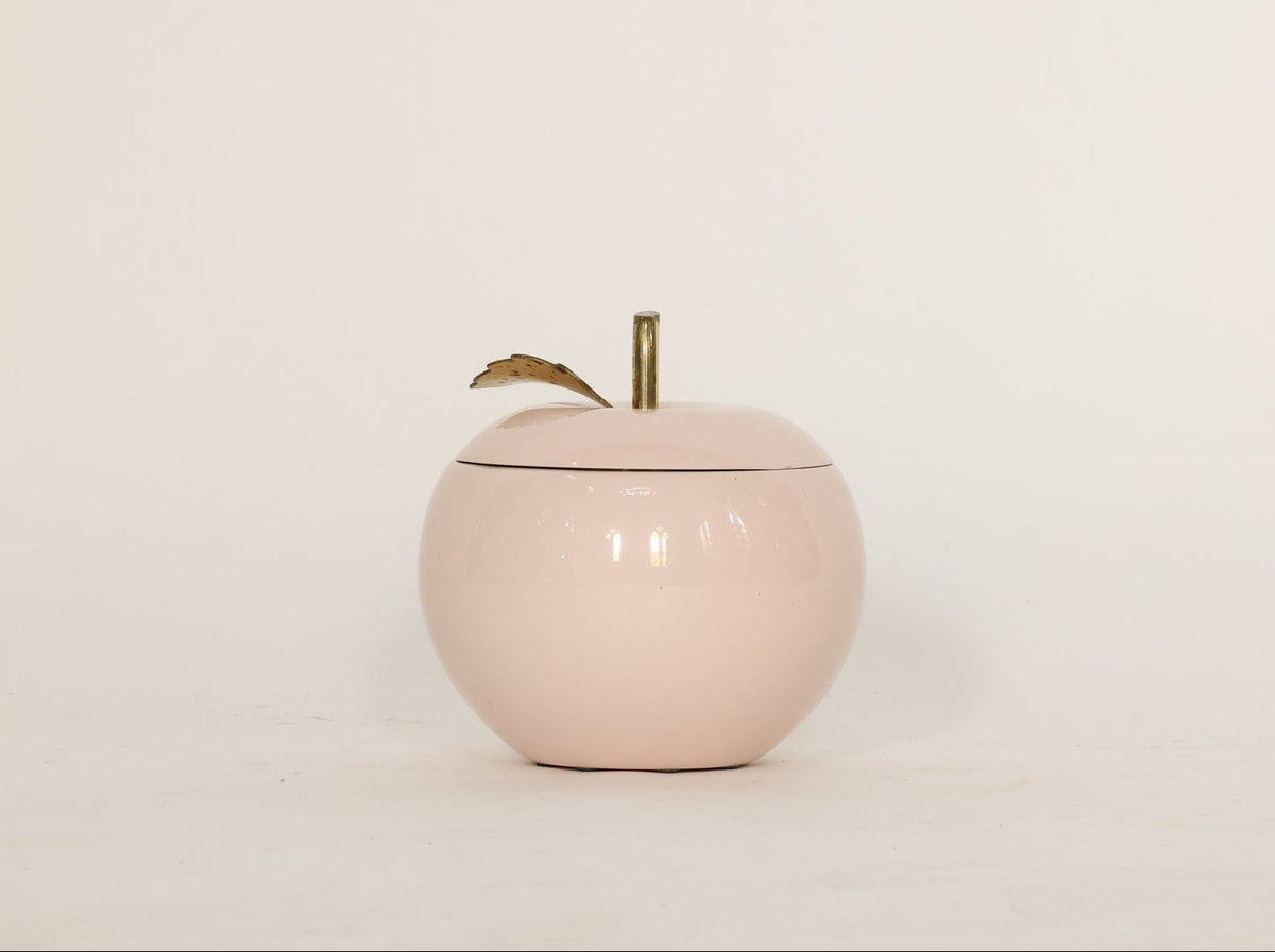 Pink ceramic apple-shaped container on a white background