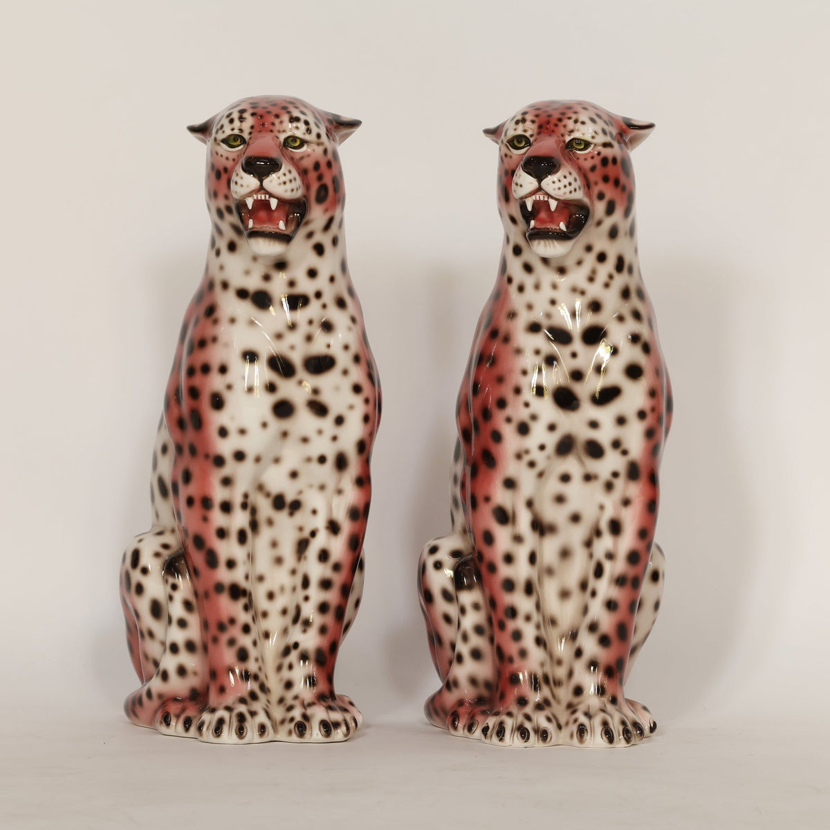 Two ceramic cheetah figurines on a white background