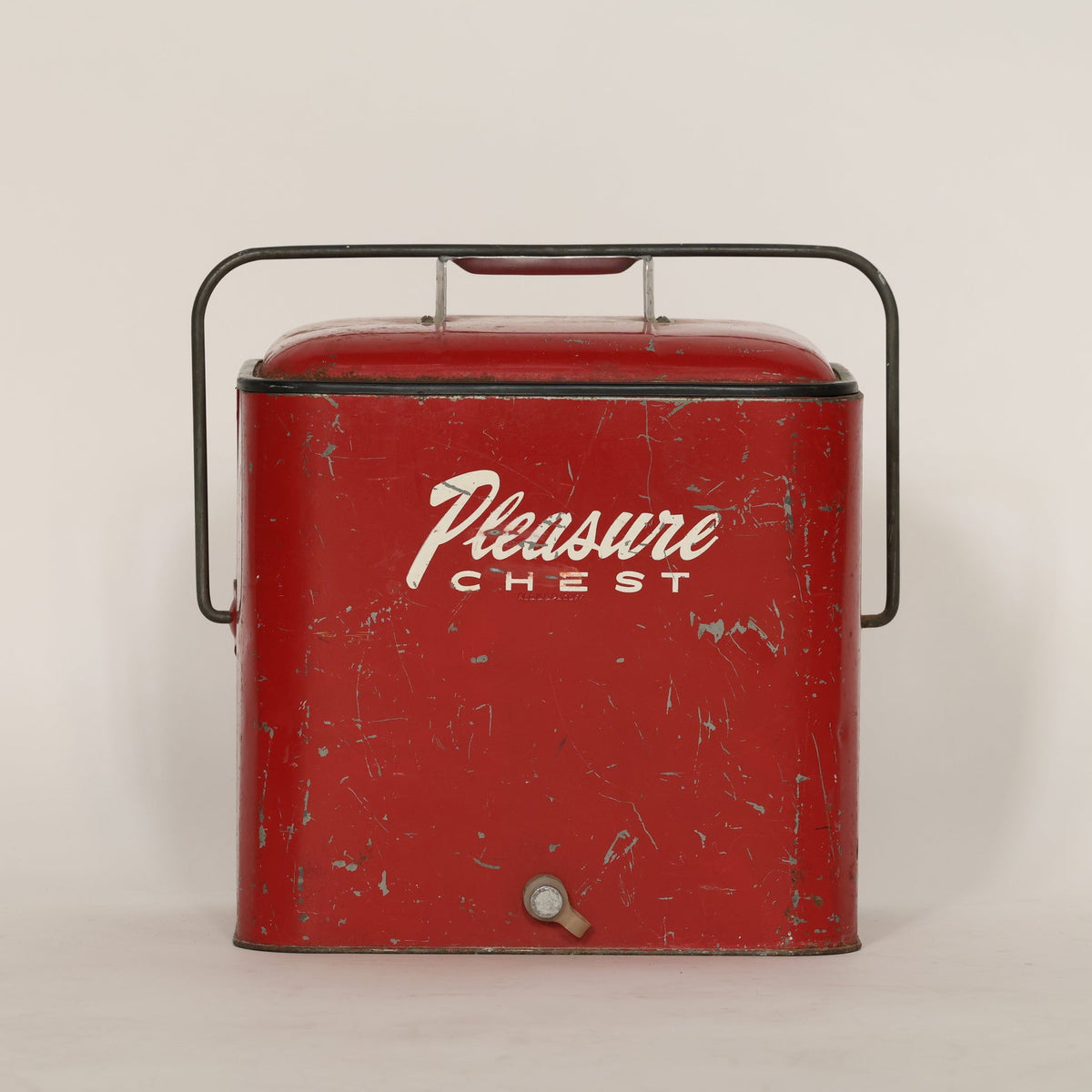 Vintage red 'Pleasure Chest' cooler on a beige background
