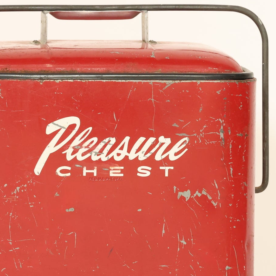 Red metal 'Pleasure Chest' cooler on a beige background