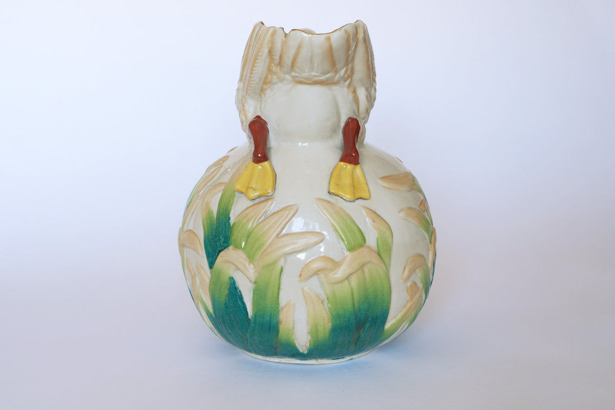 The Euro Trash Vintage Swan Motif Ceramic Pitcher features a hand-painted cattail design, round ceramic body, and petal-like top edges with yellow and red decorative accents. The background is plain white.