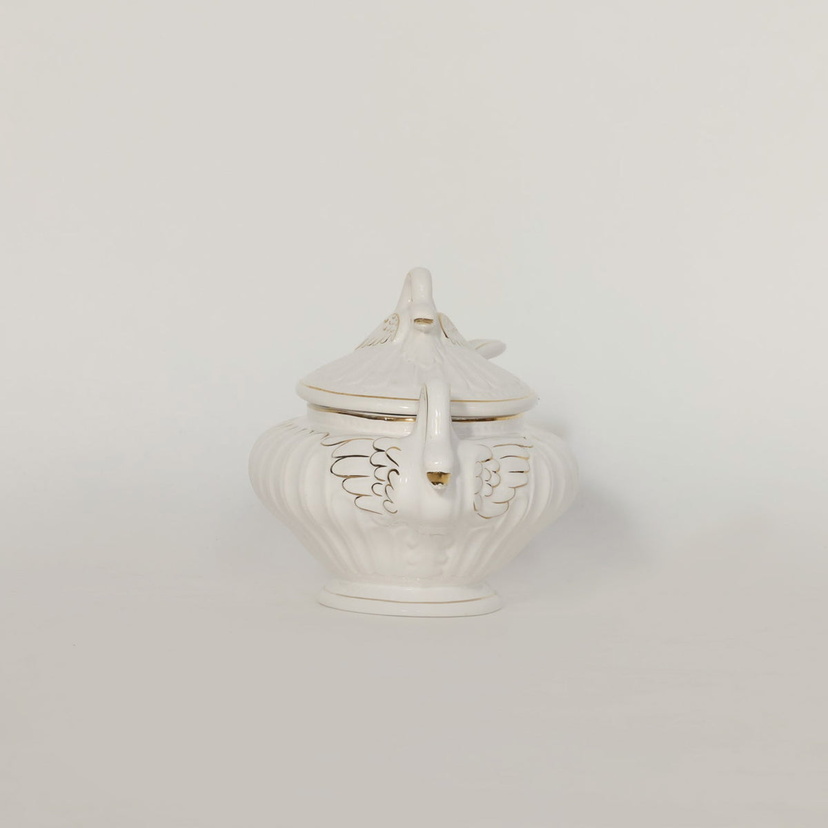 White ceramic tureen with decorative lid on a light gray background