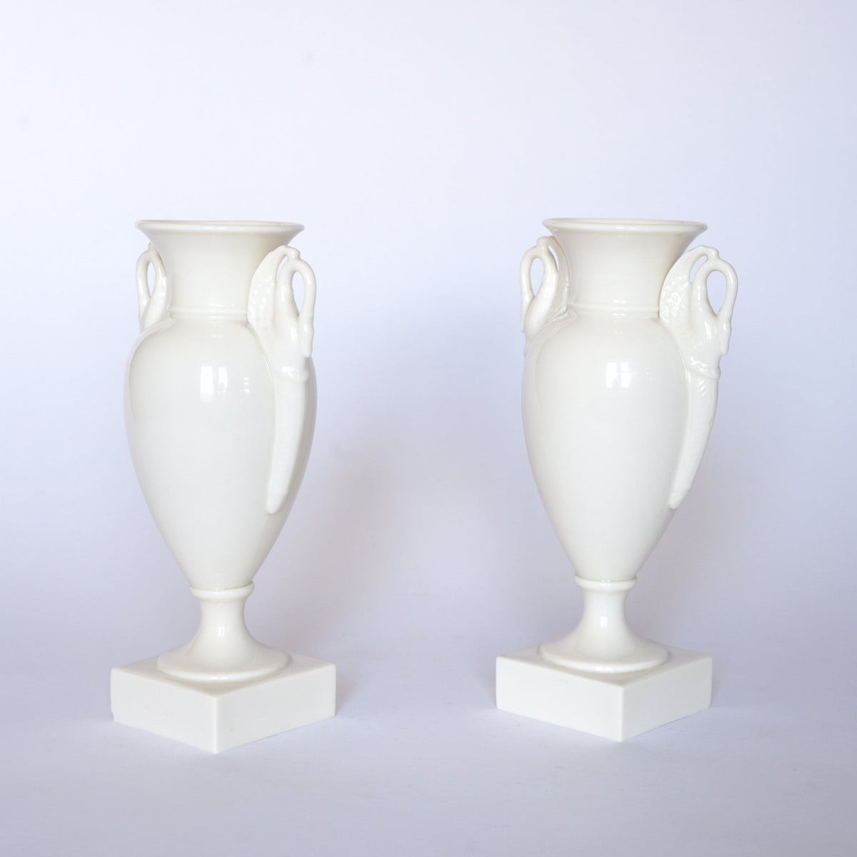 A pair of Euro Trash Vintage White Swan Handle Ceramic Urn Vases, each featuring square bases and elegant swan handles, displayed on a plain white background.