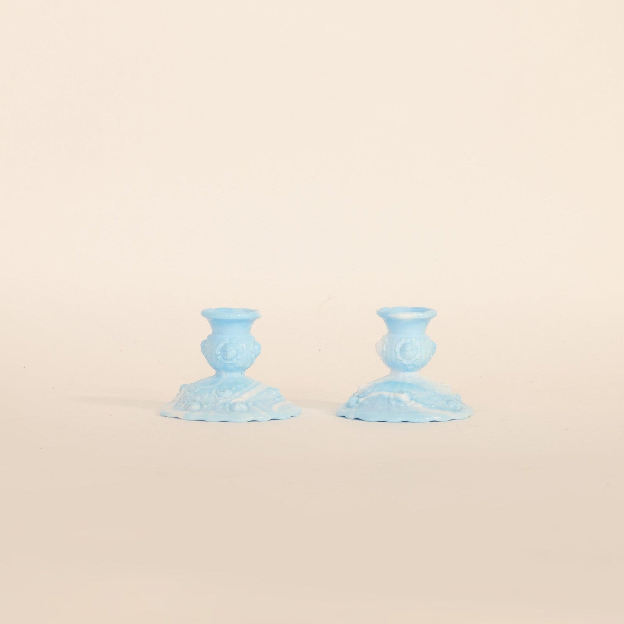 Two blue candle holders on a beige background