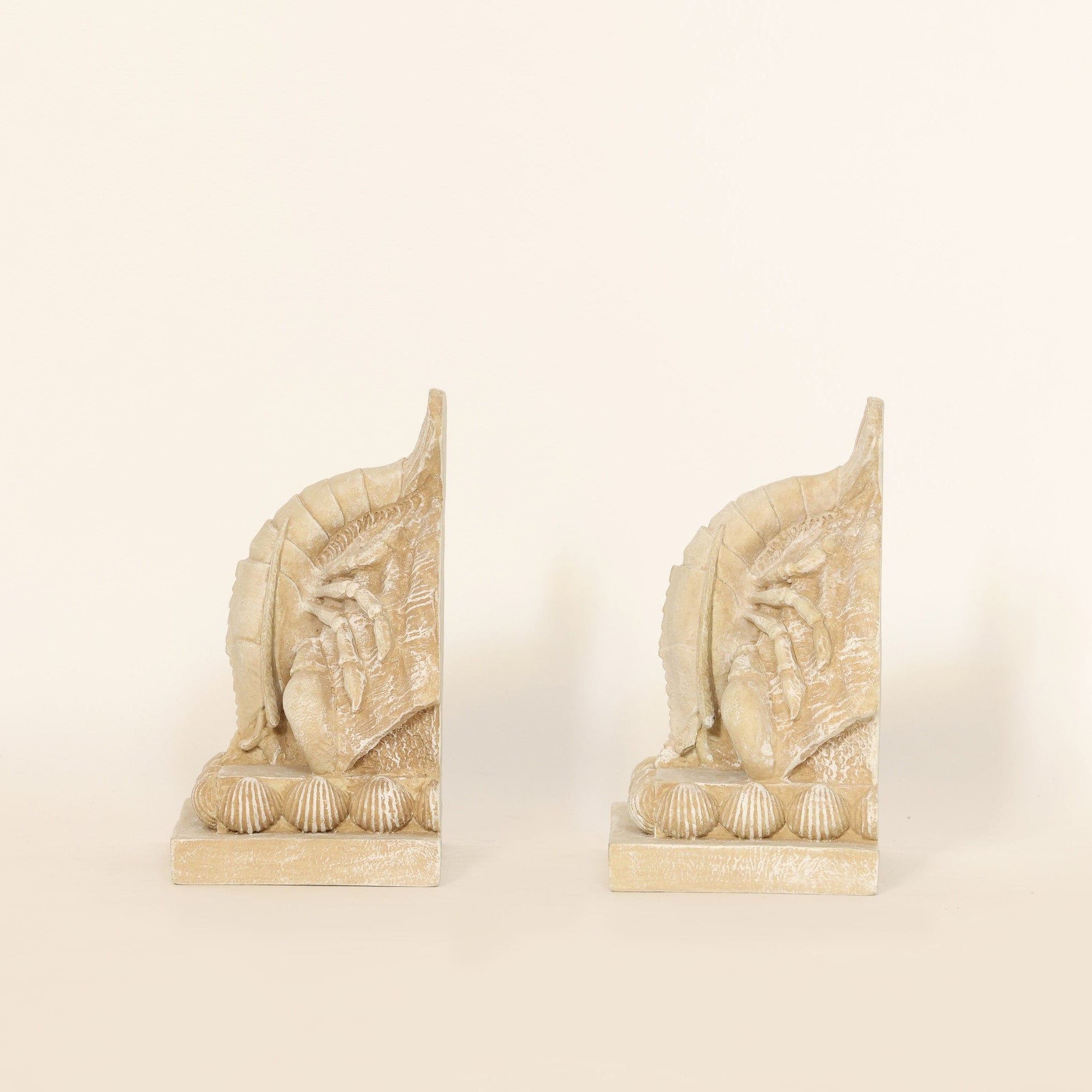 Pair of Coastal Lobster Sculptural Bookends on beige background.