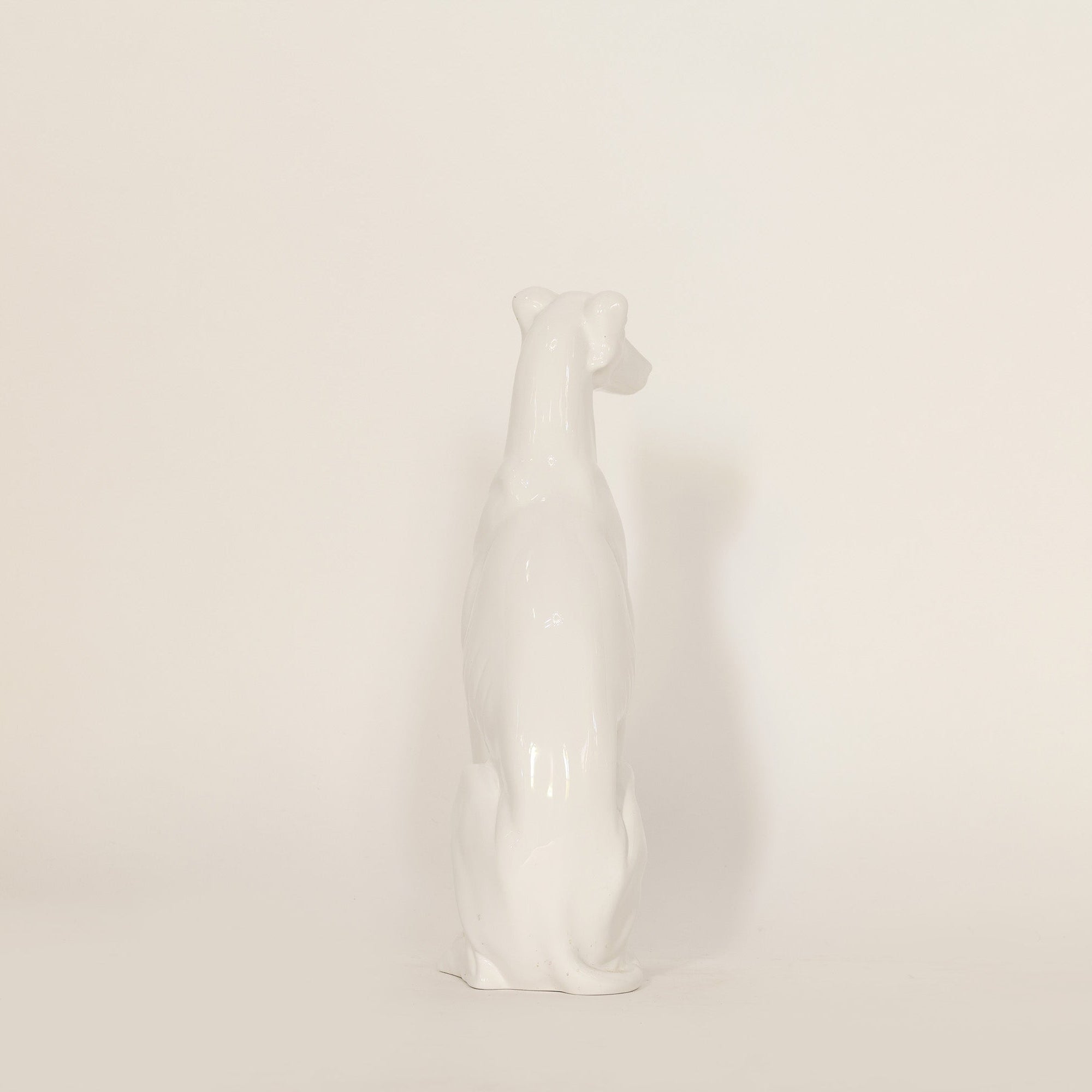 White ceramic dog figurine on a beige background