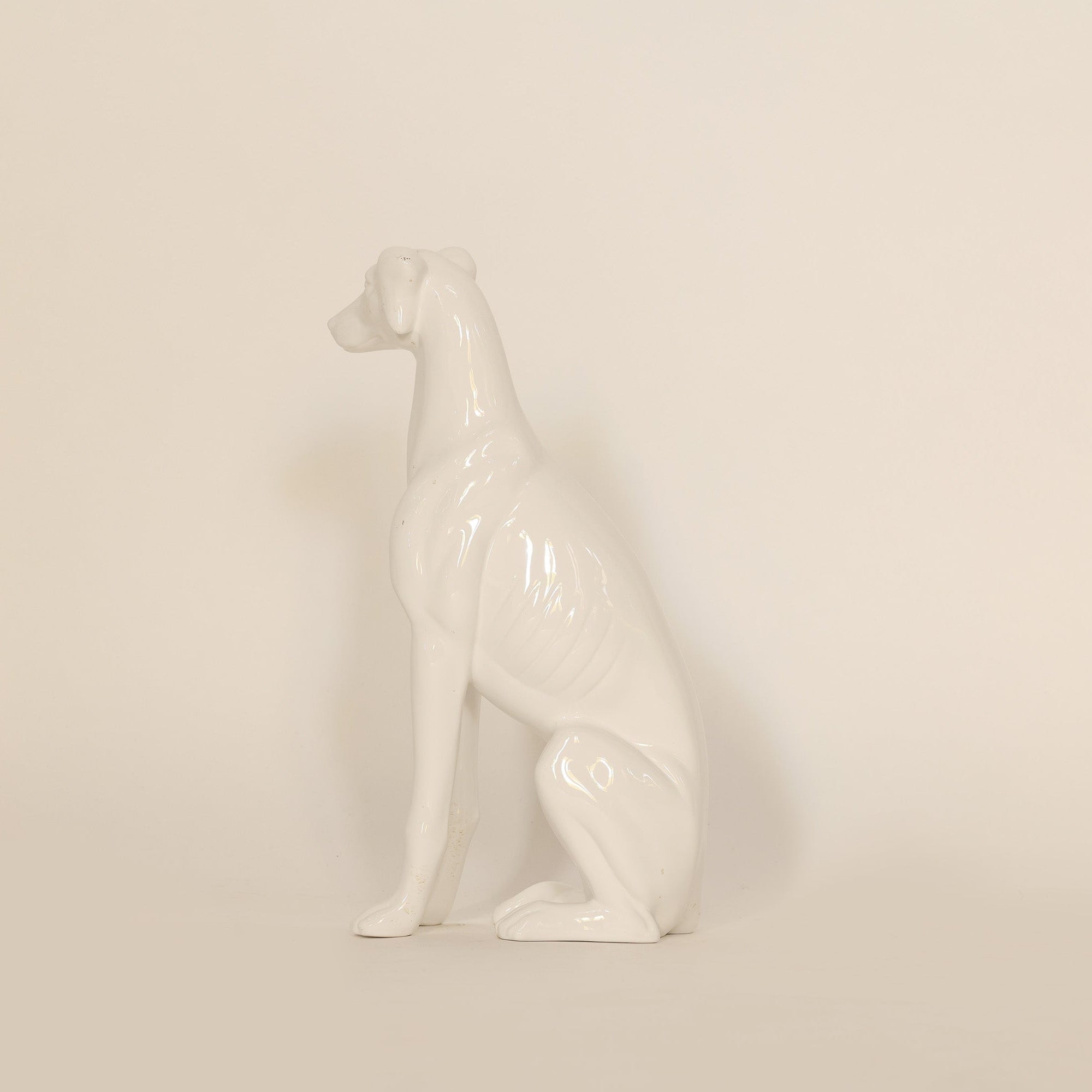 White ceramic dog figurine on a beige background