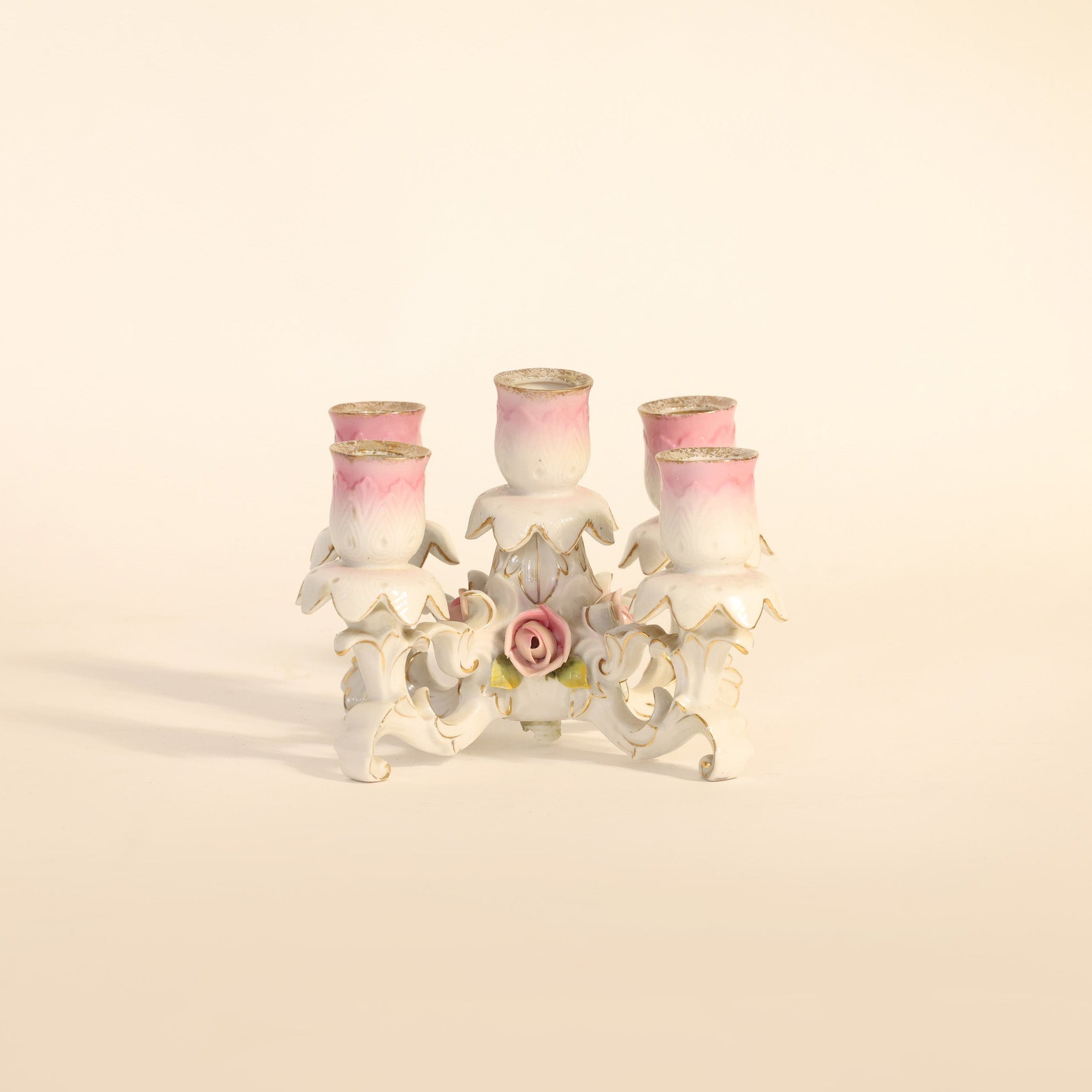 Decorative candle holder with three candles on a beige background