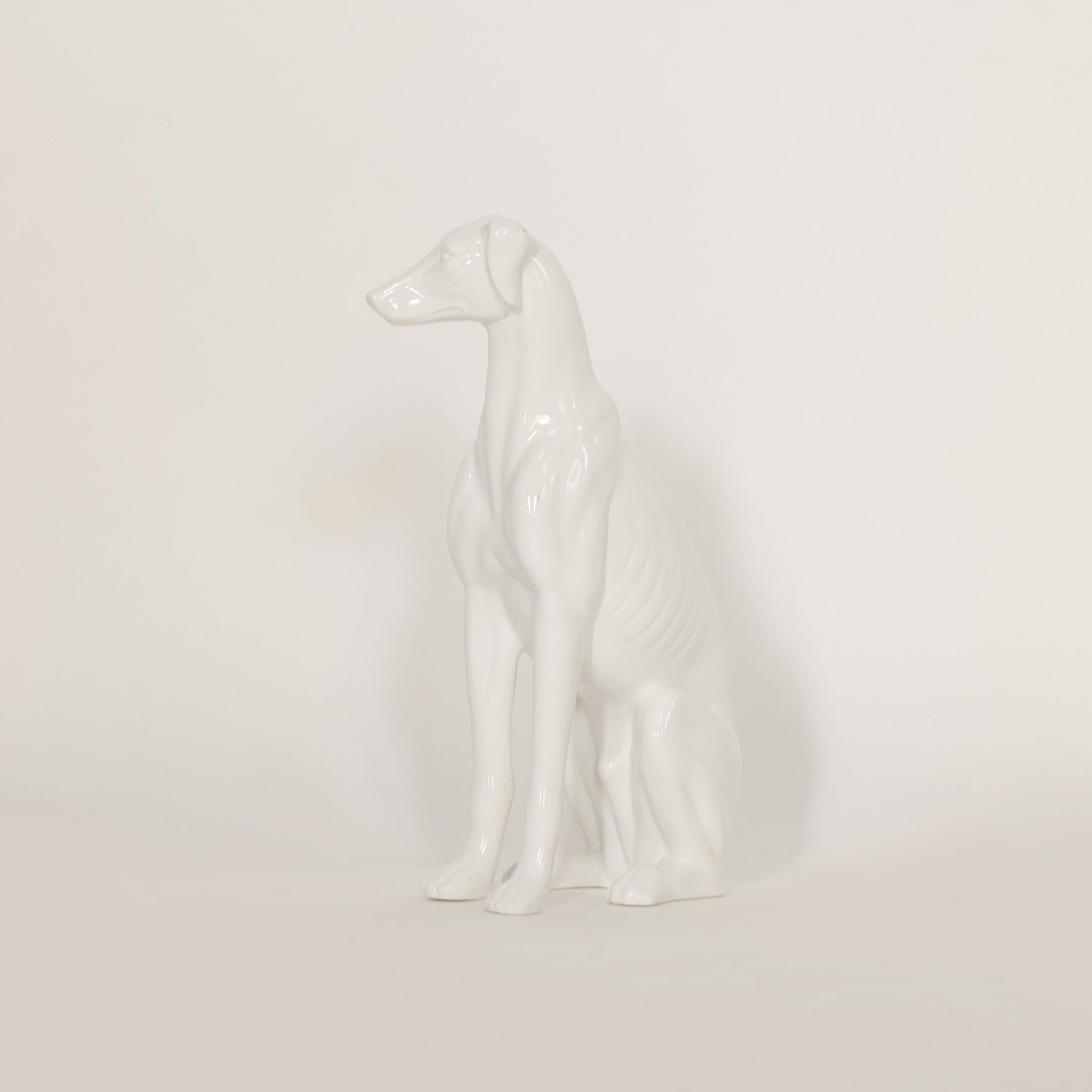 White ceramic dog figurine on a light beige background