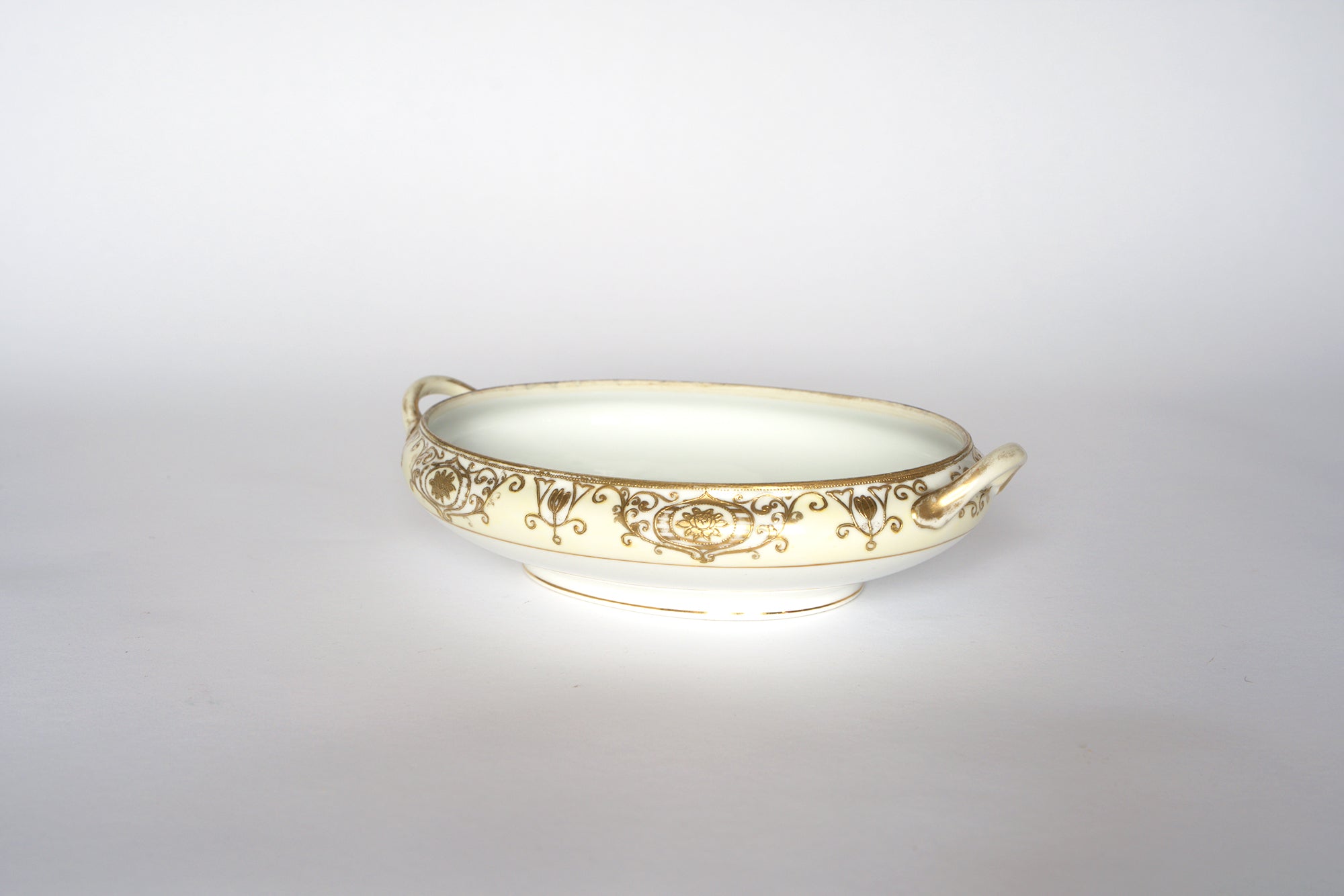 Two Noritake vintage porcelain serving bowls by Euro Trash, featuring white porcelain with two small side handles and intricate gold floral and scroll designs—ideal for any decorative china collection.