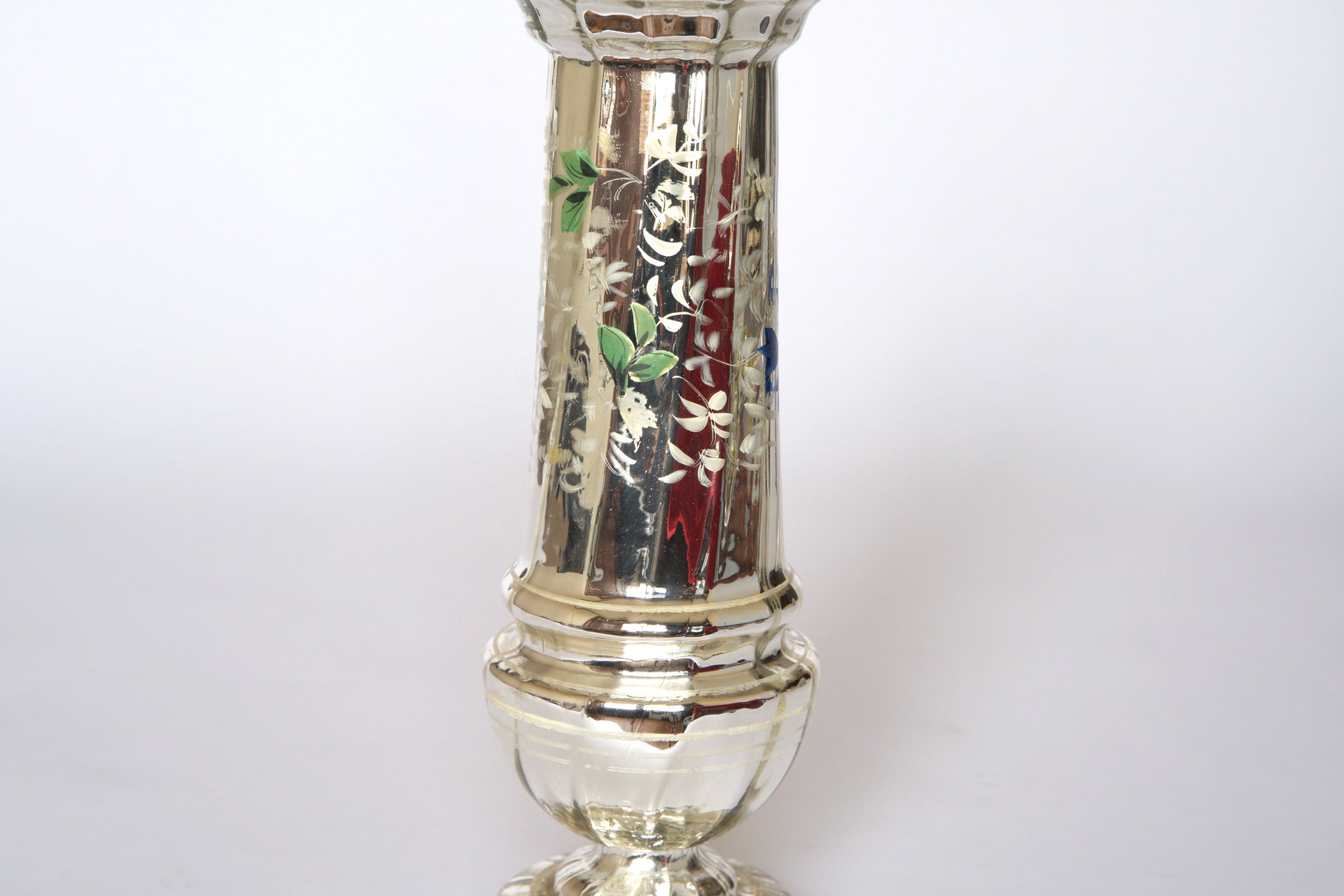 A close-up of the Pair of Vintage Silver Mercury Glass Vases by Euro Trash, featuring reflective surfaces and hand-painted green leaves and white flowers, set against a plain white background.