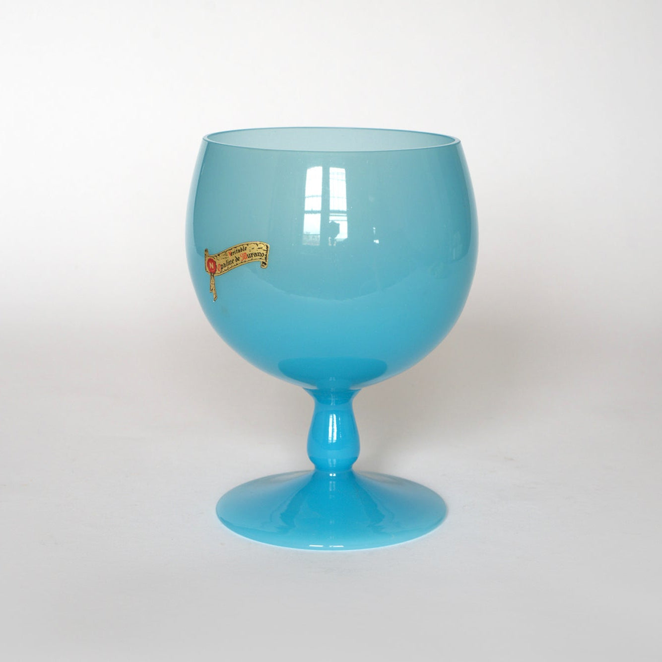 The Euro Trash Vintage Blue Opaline Murano Glass Goblet features a large, opaque bowl with a short stem and small label near the rim, shown against a plain white background.