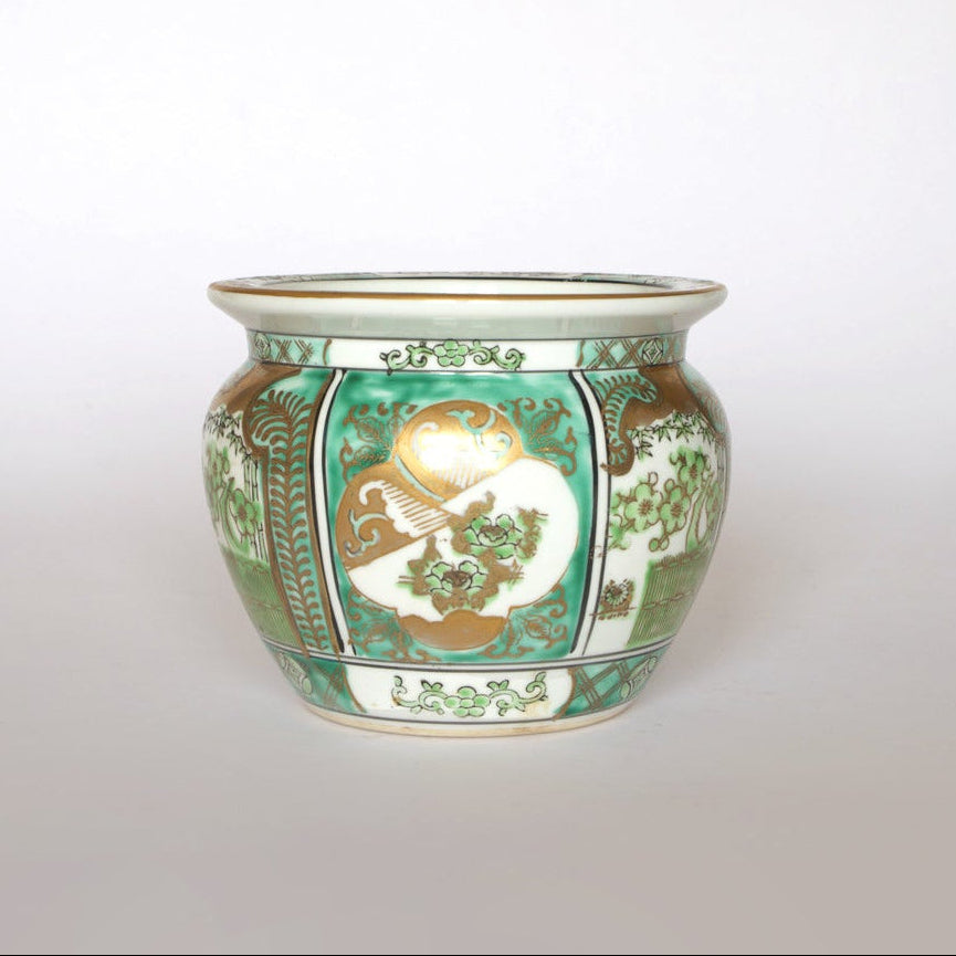 The Euro Trash Vintage Green and Gold Asian Motif Porcelain Cachepot features a round shape, wide rim, and floral Asian-inspired designs in green, gold, and white on a white background. Shown against a plain, light backdrop.