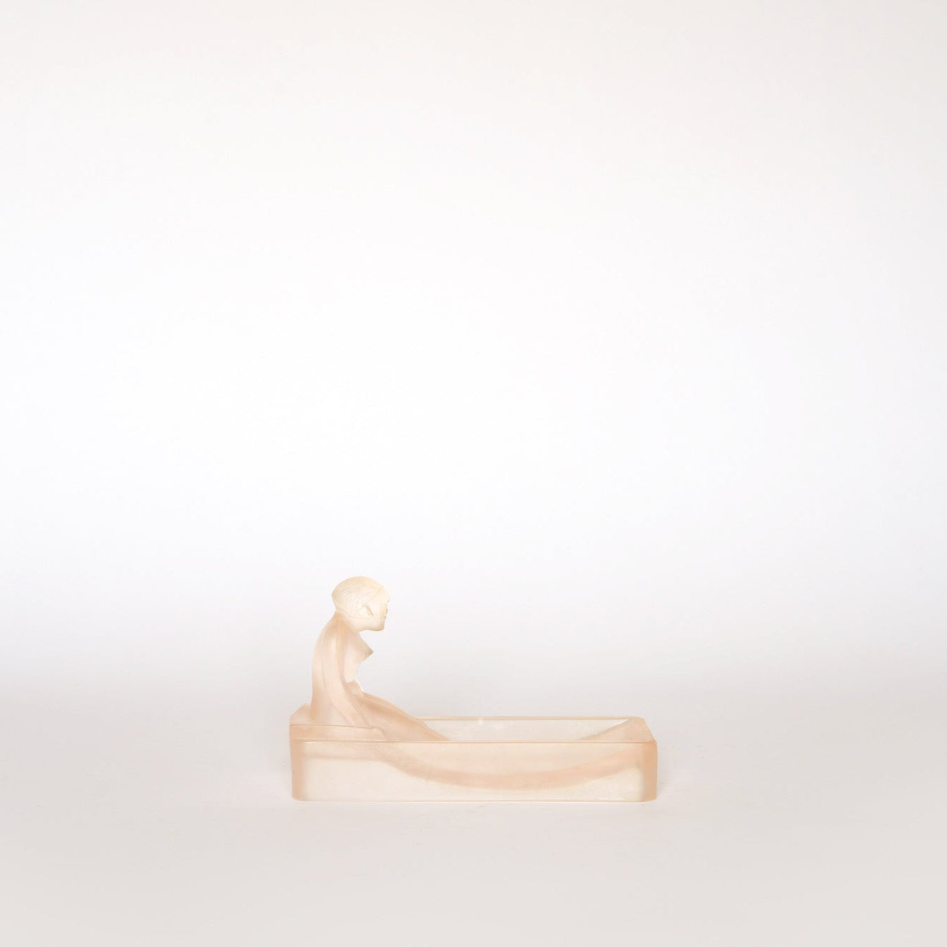 The Euro Trash Vintage Frosted Glass Figural Trinket Dish features a minimalist seated figure in a rectangular tub, crafted from frosted glass and set against a light backdrop, with subtle Art Deco-inspired design.