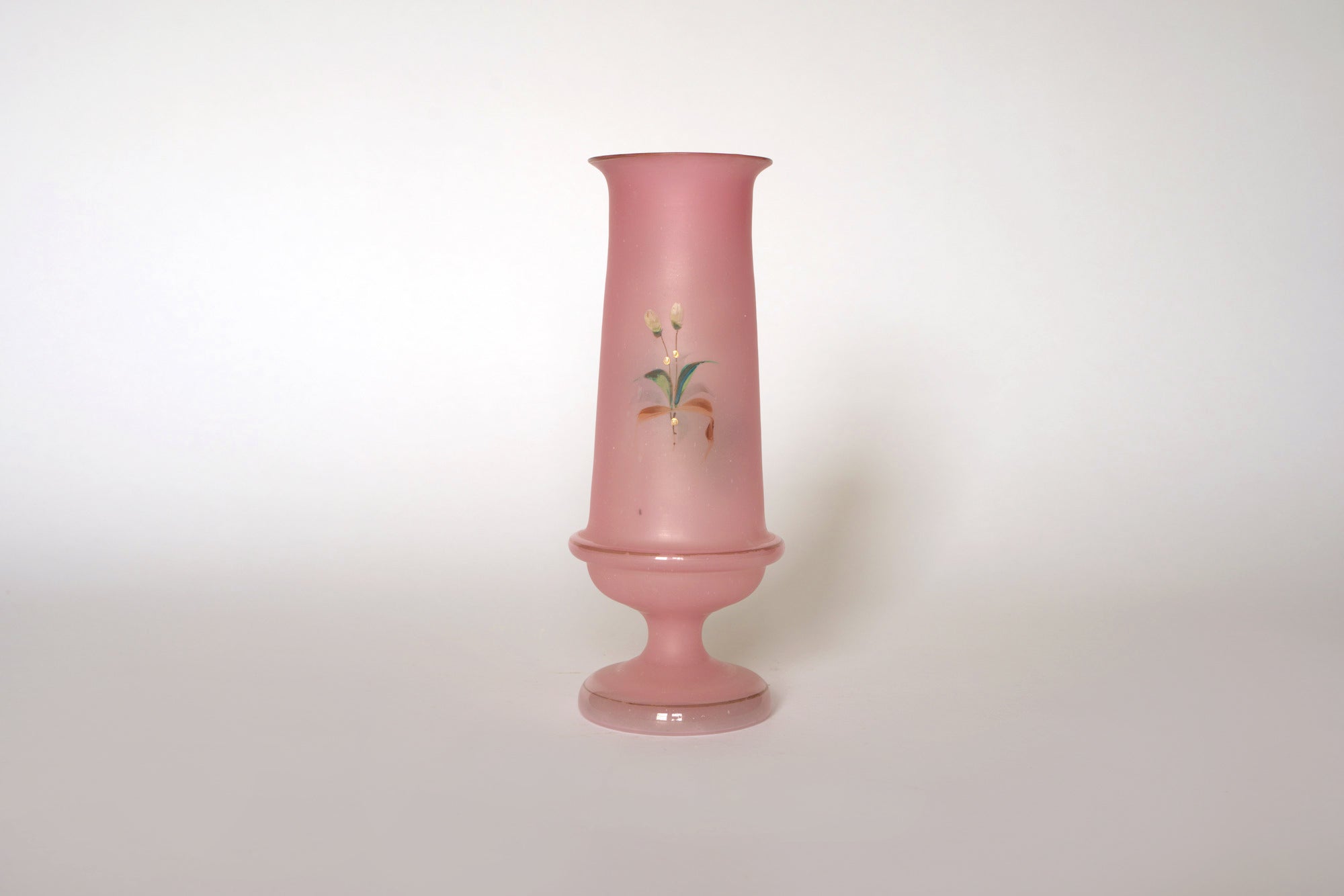 The Euro Trash Vintage Pink Floral Glass Vase features a hand-painted design on a tall, pink glass body with a narrow neck and wide base, set against a plain white background.