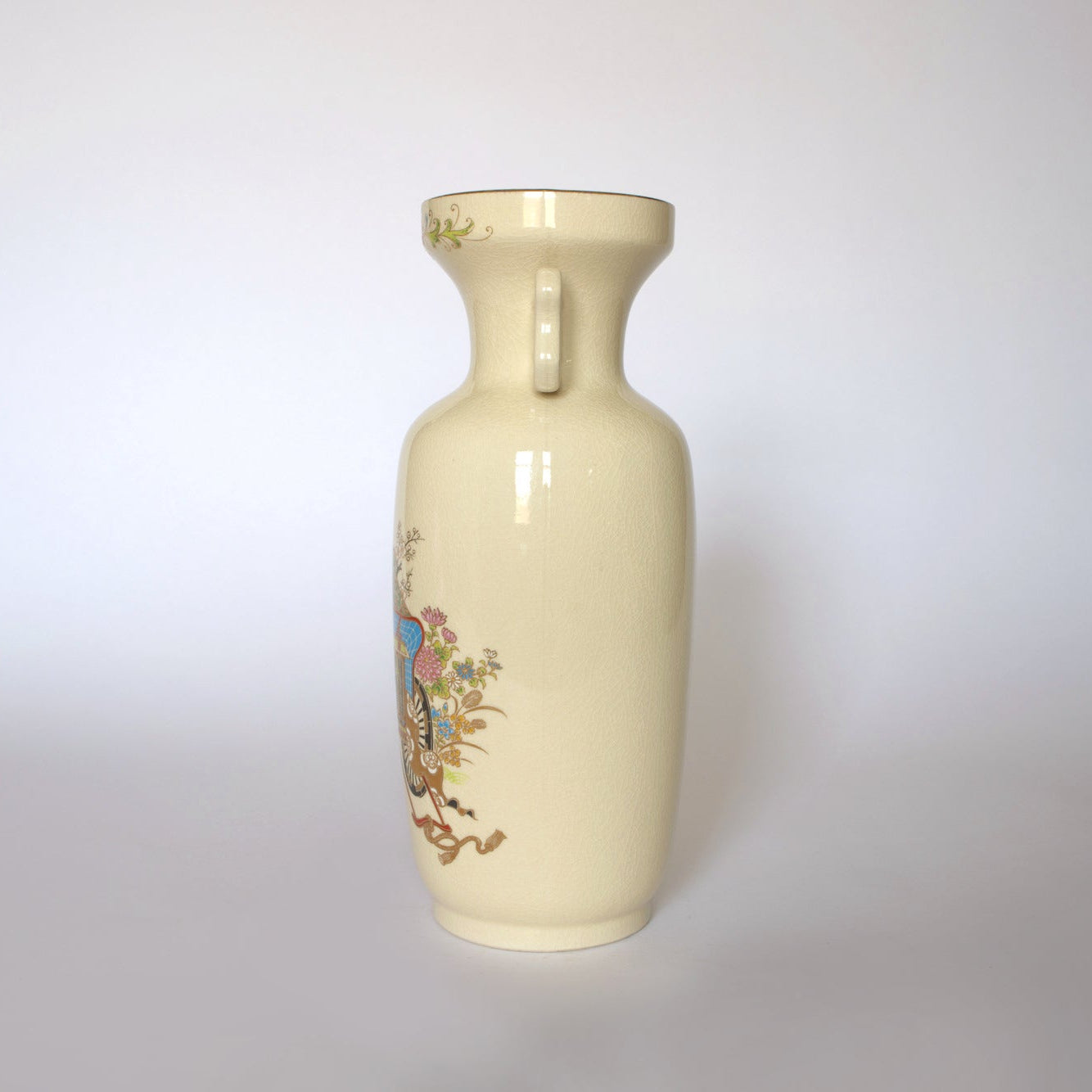 The Euro Trash Vintage Japanese Satsuma Style Ceramic Vase features a tall, cream-colored design with a narrow neck, small handle, and colorful floral and bird motifs on one side against a plain light background.