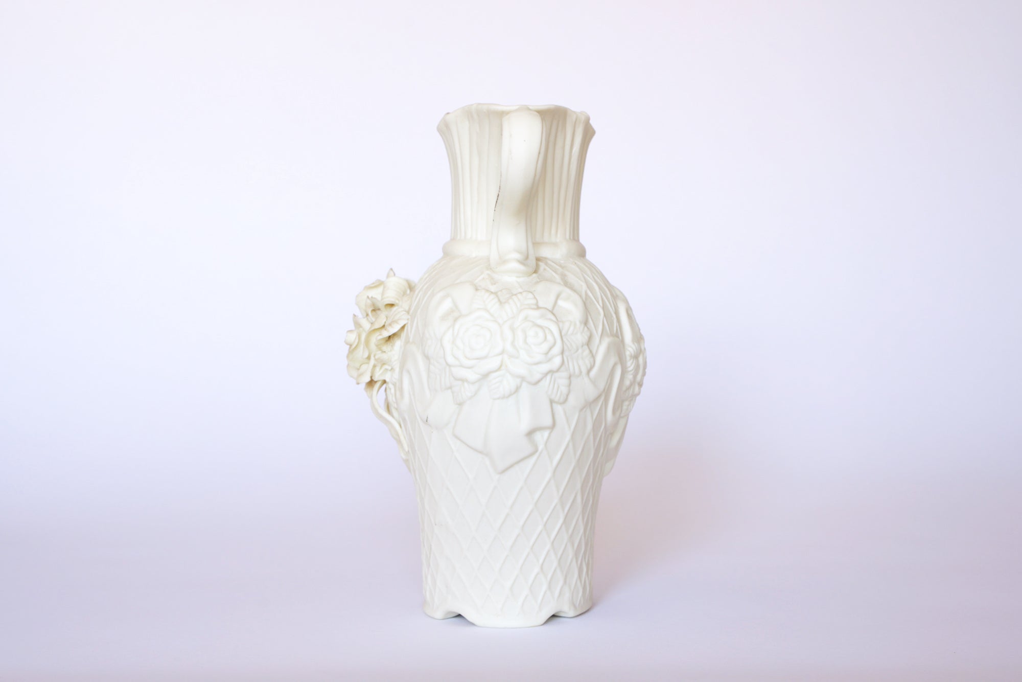 The Euro Trash Annie Vintage White Ceramic Relief Floral Vase features a textured surface with intricate raised floral detailing, displayed against a plain white background.