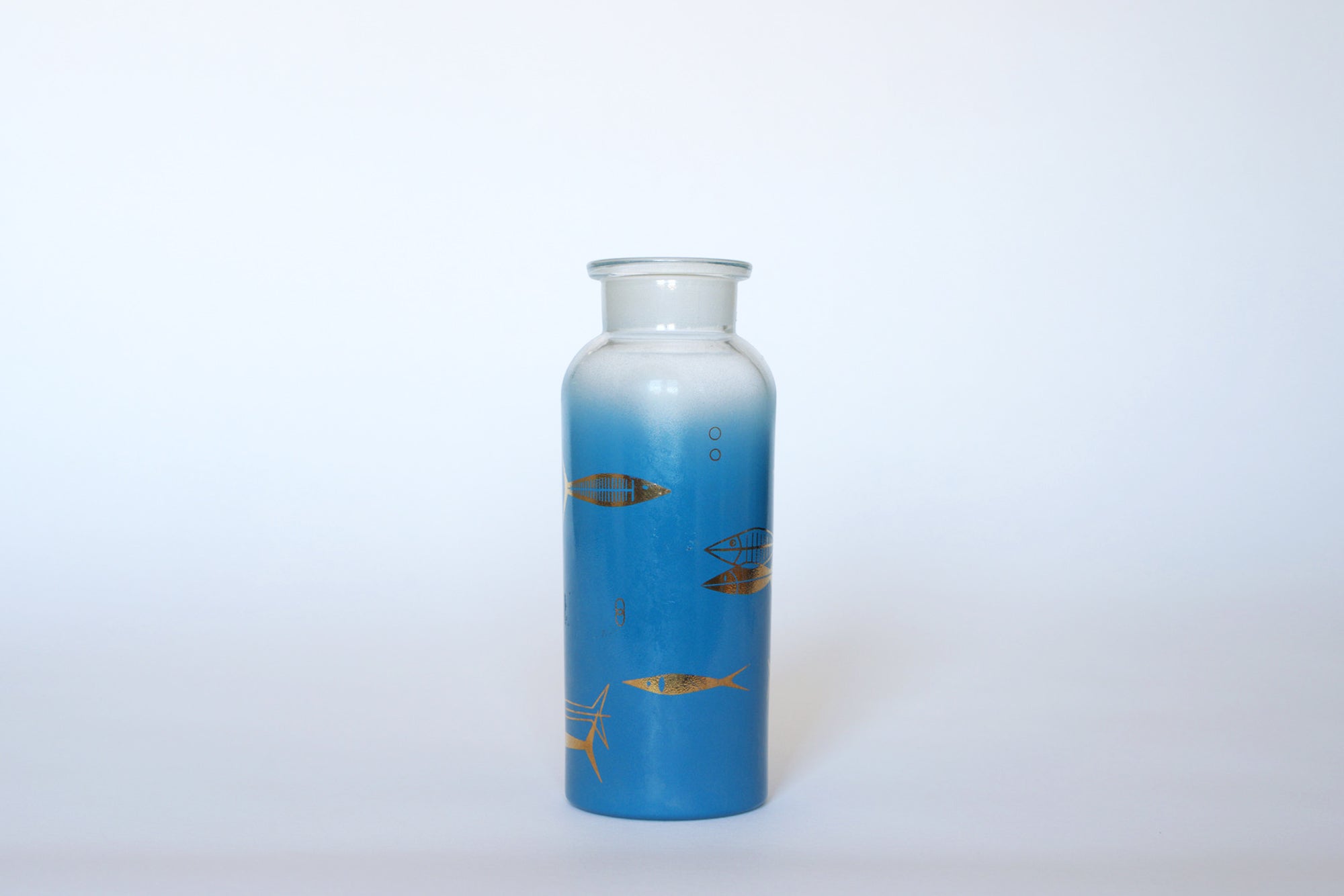 The Euro Trash Vintage Blue Frosted Glass Vase features a tall blue gradient design with yellow and brown goldfish motifs swimming around its sides, displayed against a plain white background.