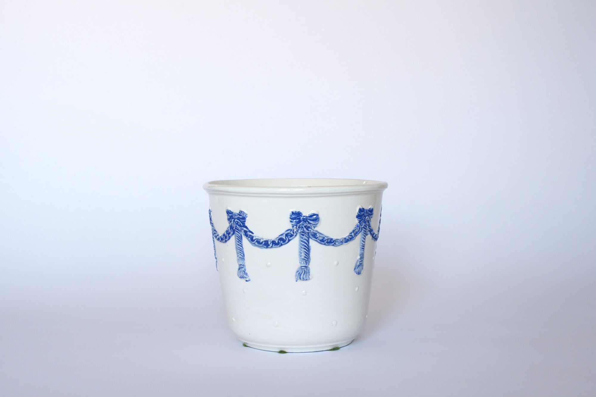 The Vintage White & Blue Ribbon Ceramic Cachepot by Euro Trash features blue ribbon detailing on white ceramic—a simple, elegant piece ideal for European-inspired decor.