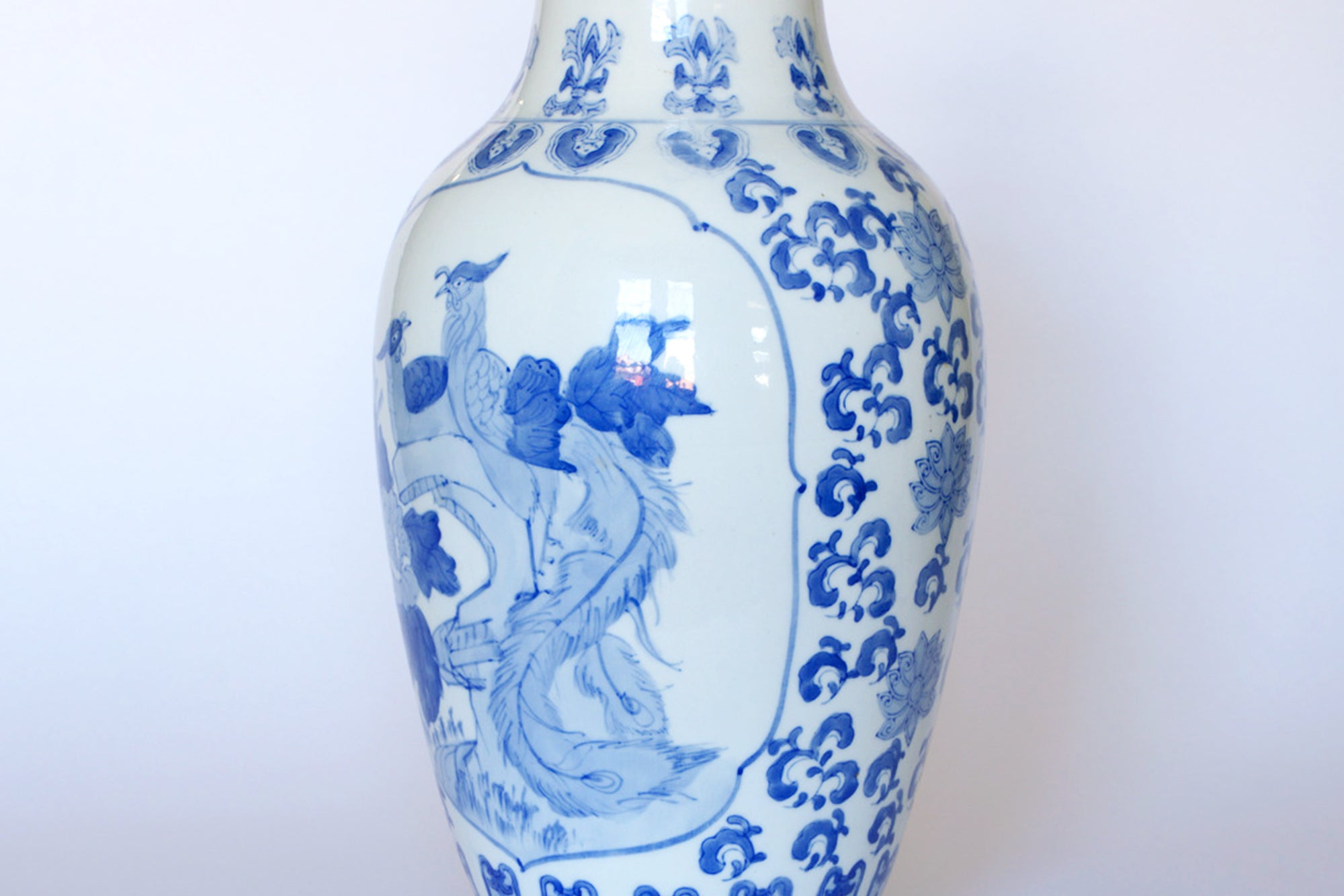 The Vintage Blue & White Porcelain Peacock Vase by Euro Trash features elegant blue bird and floral designs, capturing vintage porcelain charm—an ideal piece for Asian-inspired decor, beautifully displayed against a light background.
