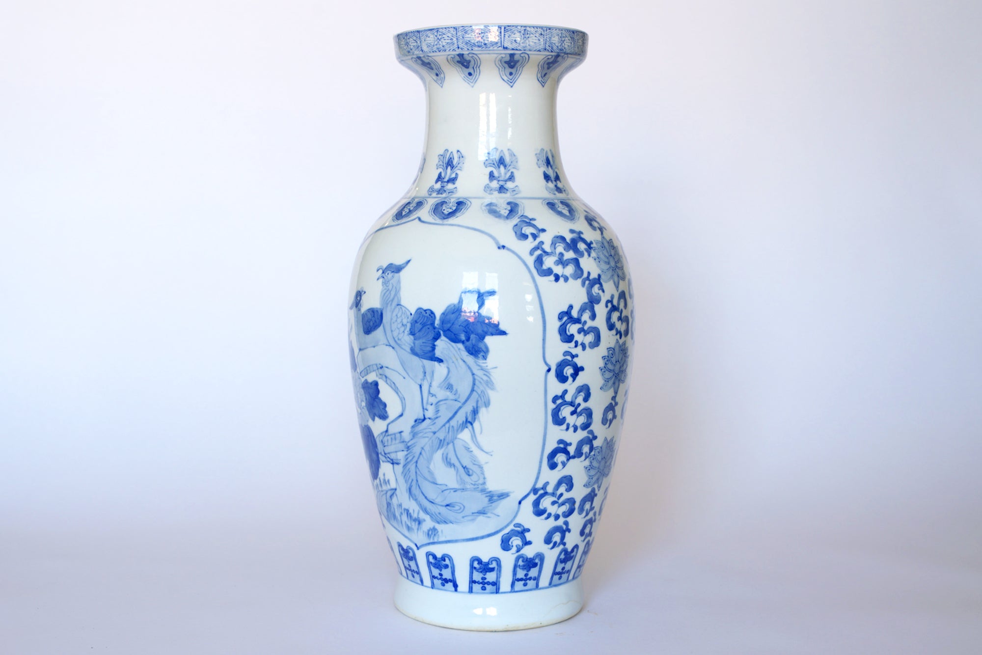 The Euro Trash Vintage Blue & White Porcelain Peacock Vase features traditional Chinese patterns, floral and peacock motifs, a tall narrow neck, and a flared rim—a classic Asian decor piece.